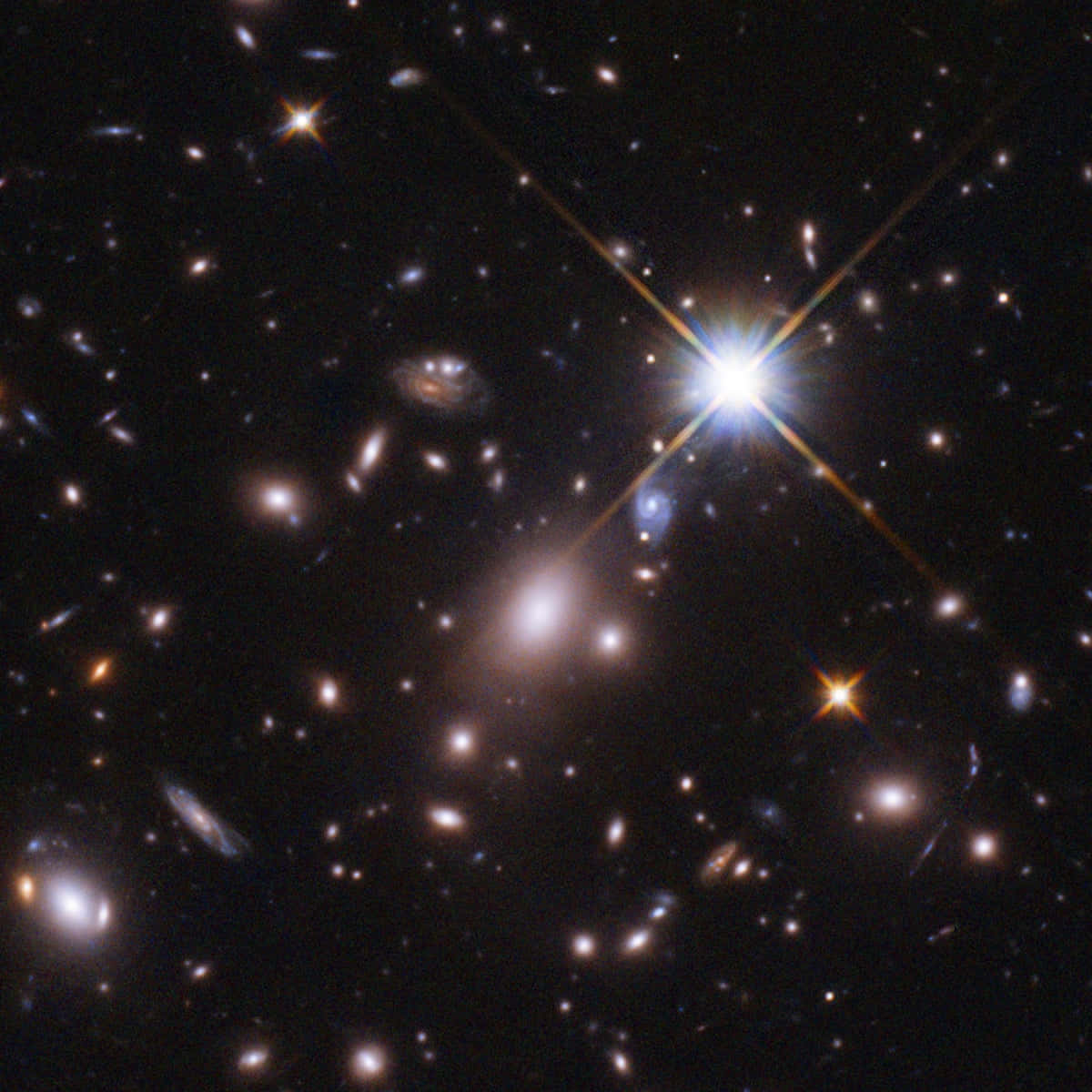 哈勃望遠鏡拍攝的遙遠星系 壁紙 — 一個宇宙景觀，展示遙遠的星系和明亮的星星，帶有鏡頭光暈效果，背景是深邃的黑色虛空。