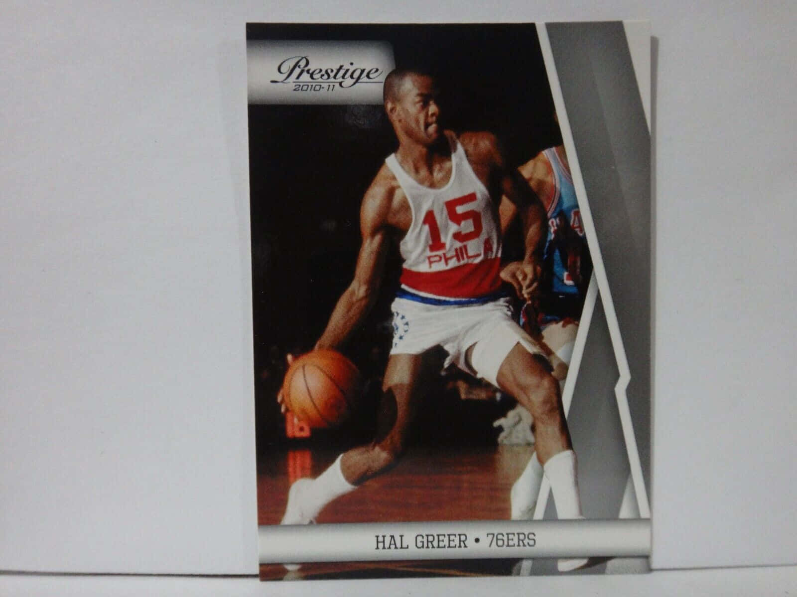 身穿76ers球衣的Hal Greer在球場上運球。