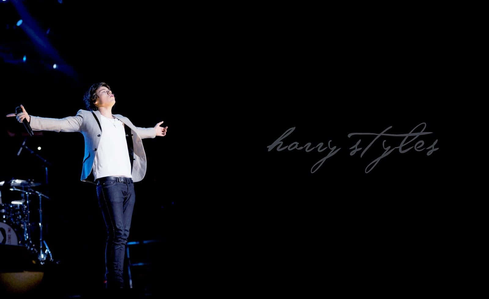 Harry Styles 在藍色燈光下張開雙臂在舞台上表演。