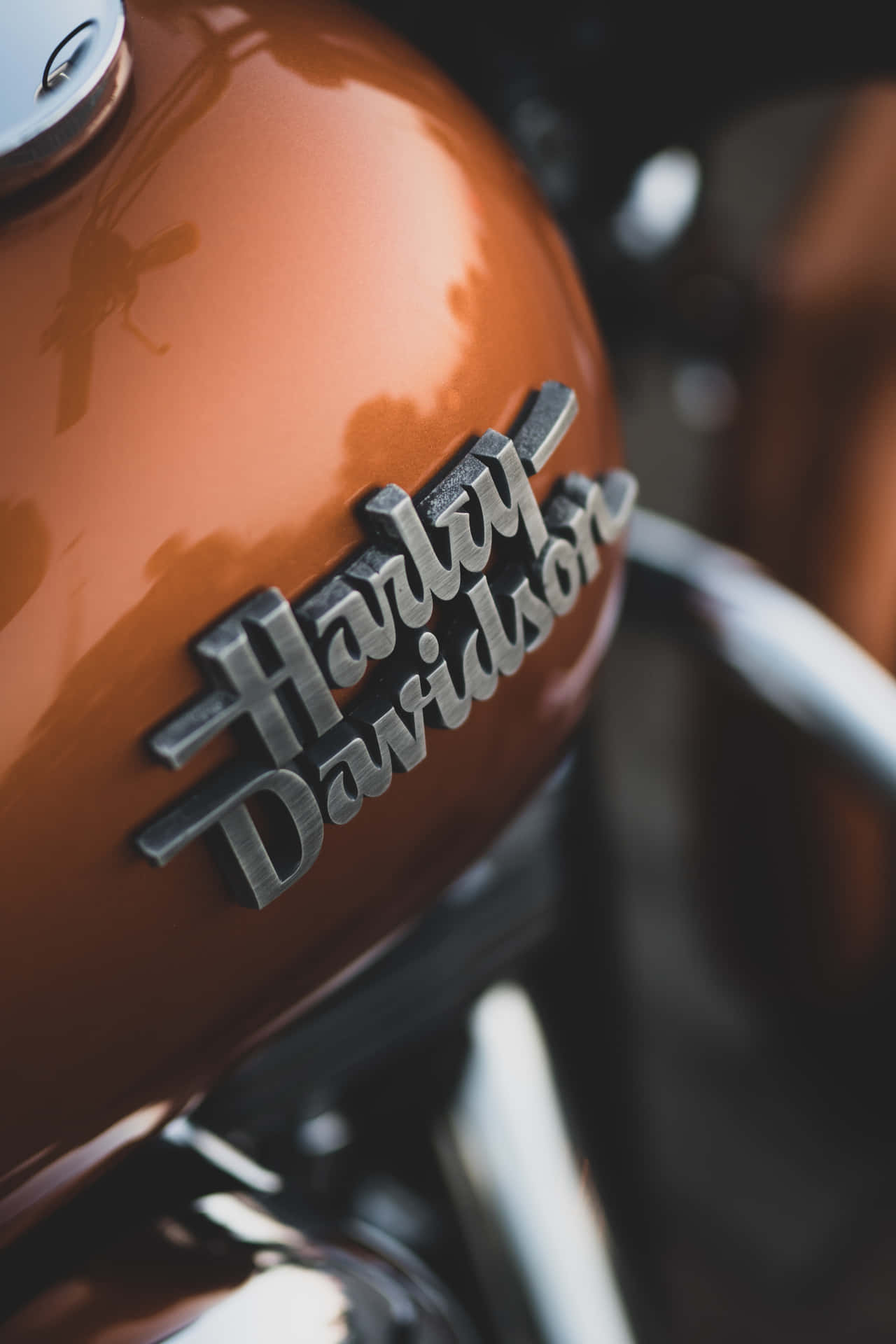 焦點清晰的光澤銅色電單車油缸，帶有鍍鉻Harley-Davidson標誌。