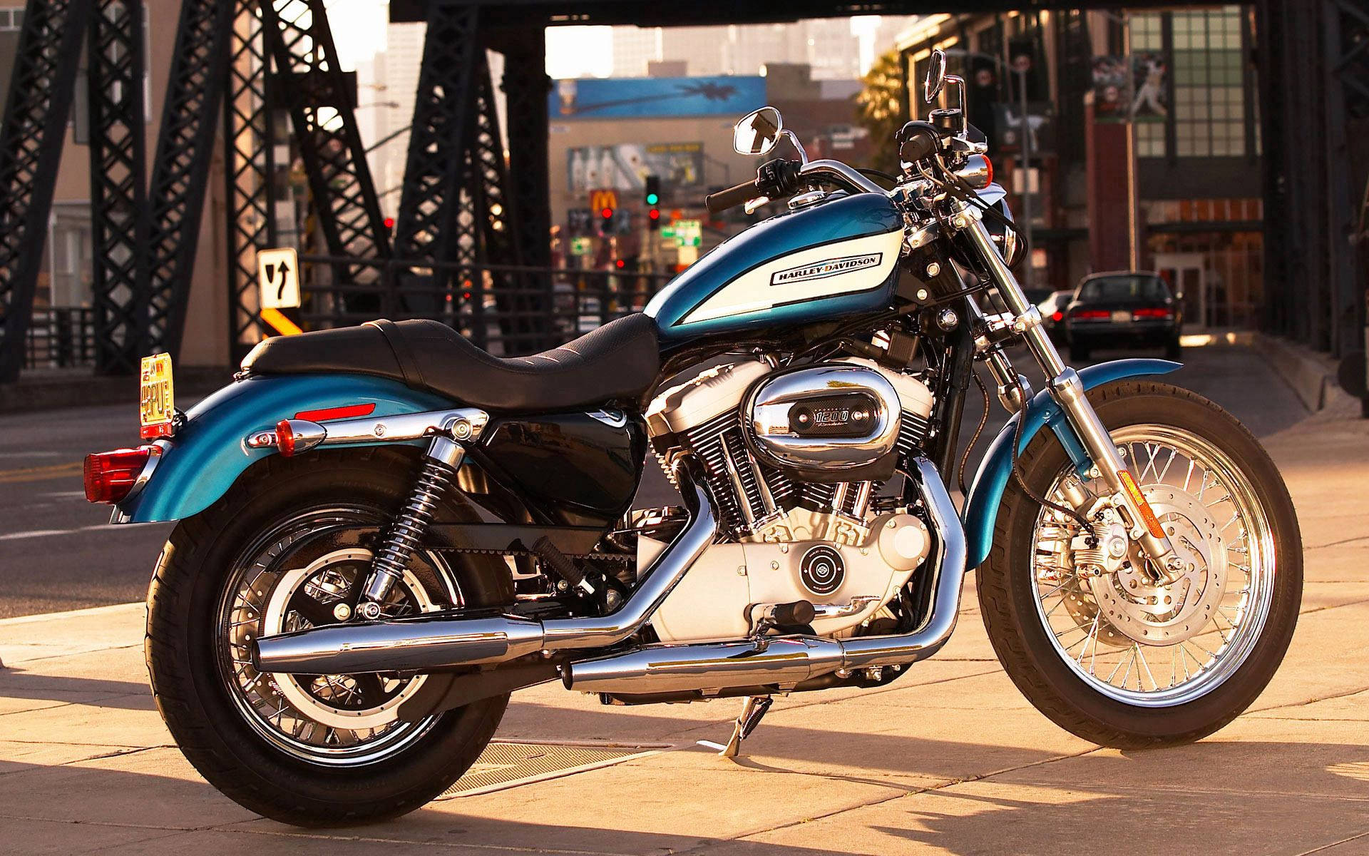 日落時分，青綠色Harley-Davidson電單車停泊在橋附近的行人路上。