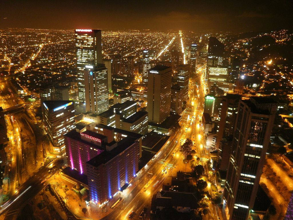 哥倫比亞波哥大 酒店Tequendama 壁紙 — 廣闊城市景觀的夜間航拍圖，閃爍的摩天大樓和燈火通明的街道延伸至遠方。