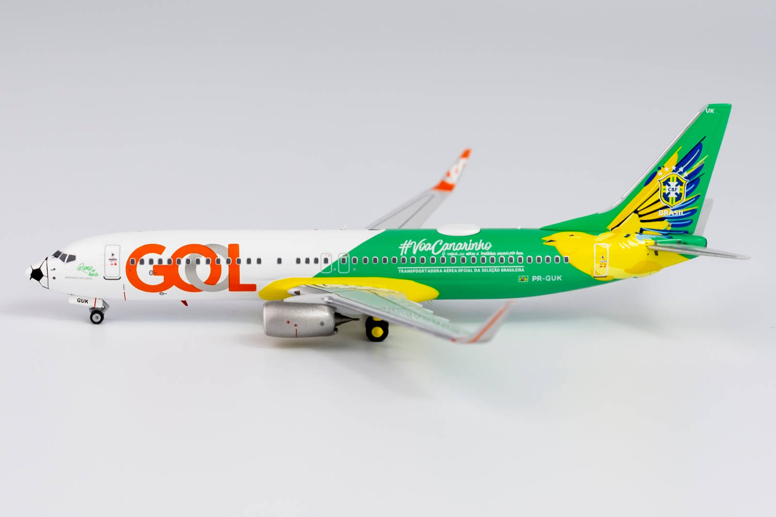 哥倫比亞航空鳥形垂尾飛機 壁紙 — GOL航空公司波音737的詳細模型，帶有綠色、黃色和橙色塗裝，背景為純白色。
