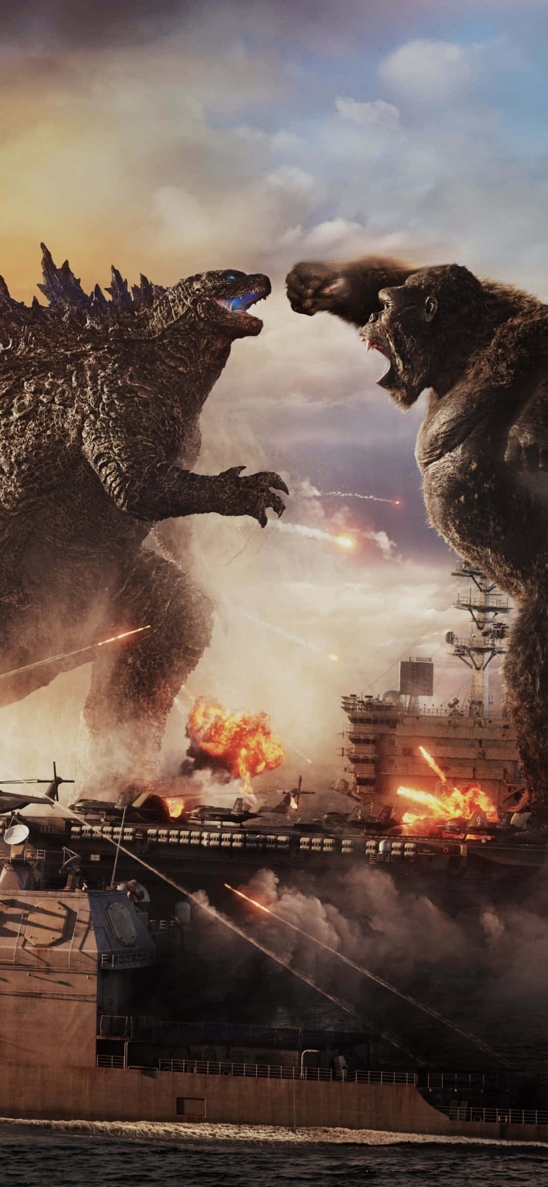 Godzilla Vs Kong 桌布 壁紙 — 哥斯拉和金剛在燃燒的航空母艦上空互相咆哮，展開一場熾熱的海戰。