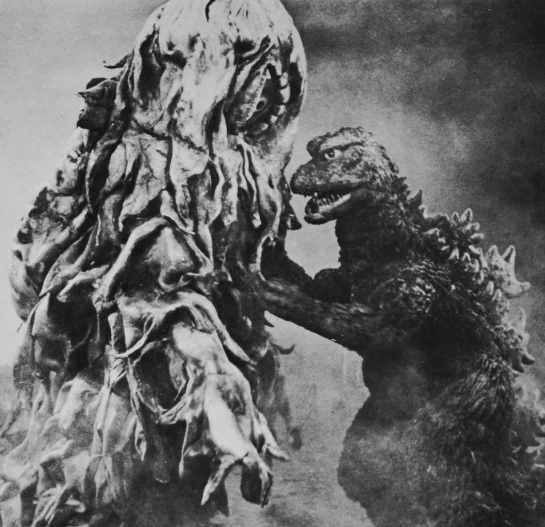 Godzilla Vs Hedorah 桌布 壁紙 — 哥斯拉在煙霧瀰漫的黑白電影對決中，面對一個怪誕、有紋理的怪物。