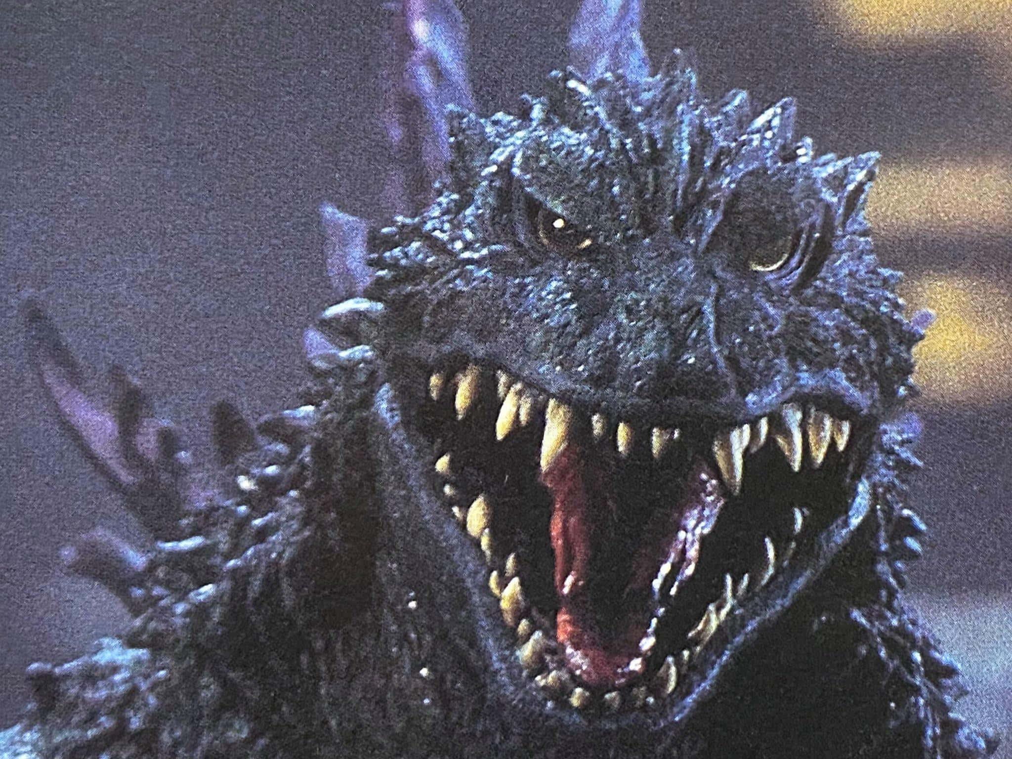 Godzilla 2000 桌布 壁紙 — 哥斯拉的近距離特寫，在黑暗煙霧背景中咆哮，眼睛發光，牙齒鋒利。