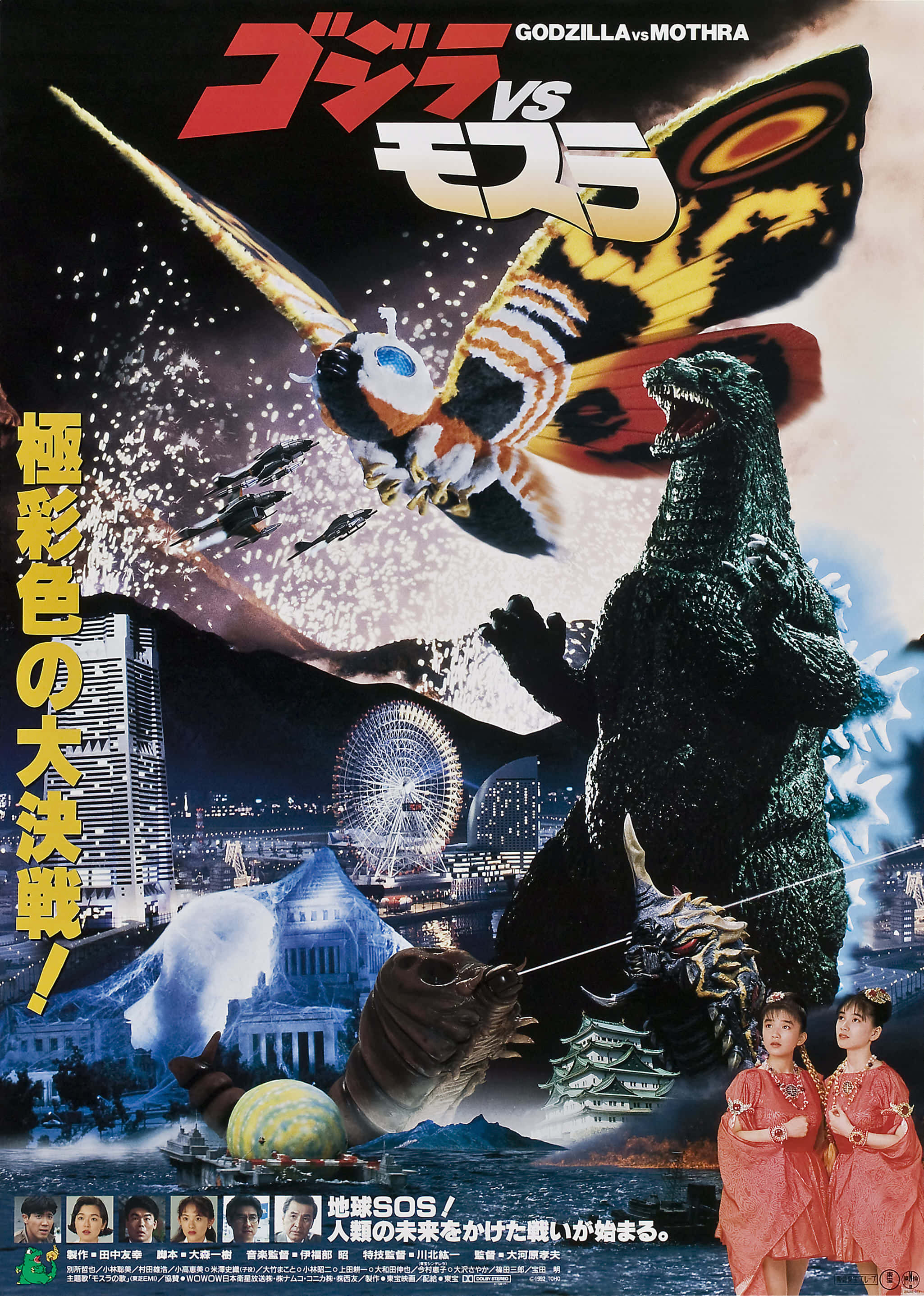 Godzilla Vs Mothra 桌布 壁紙 — 哥斯拉與摩斯拉在星空下，於有摩天輪和傳統建築的城市景觀上空交鋒。