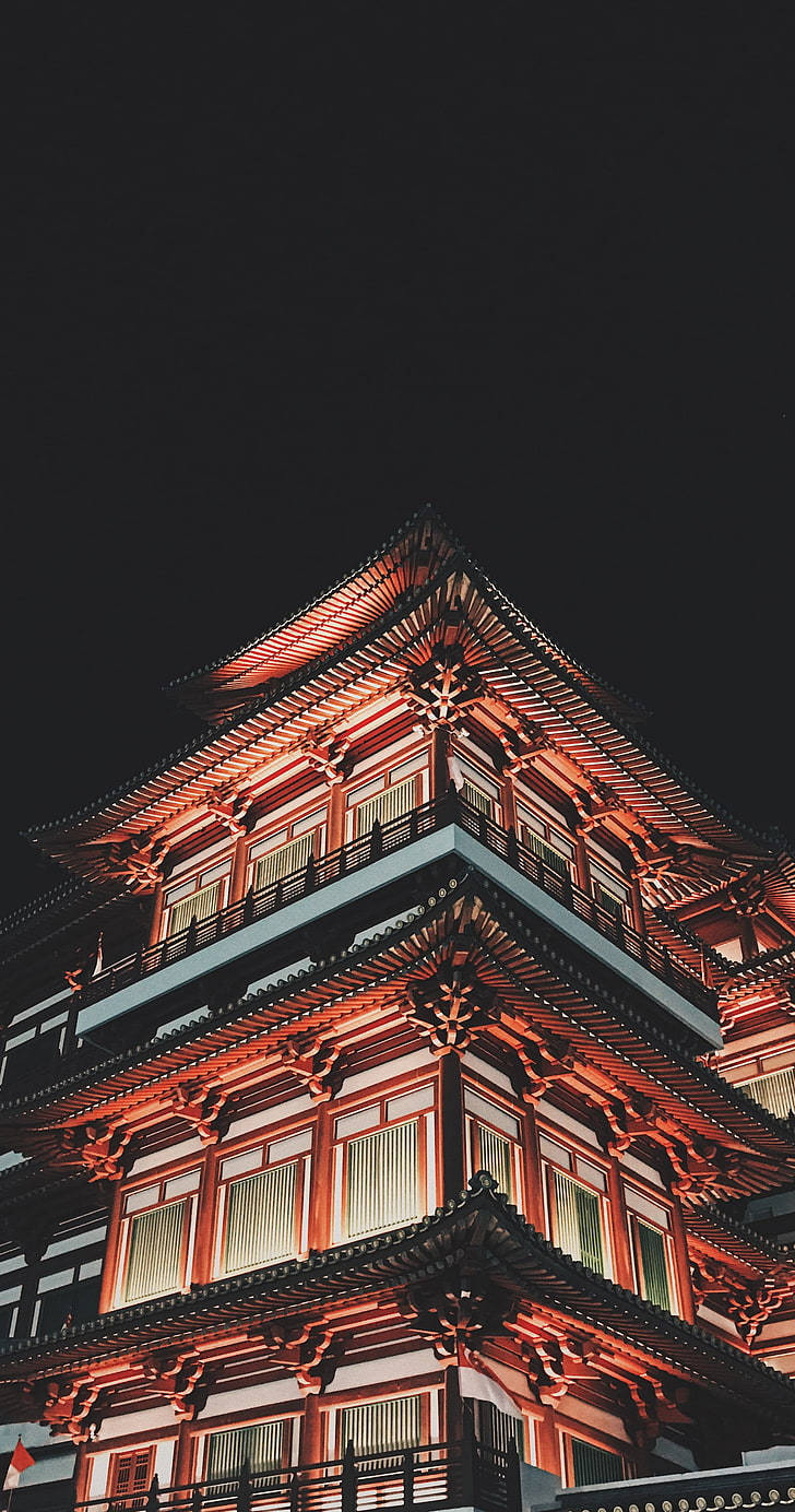 唐人街佛牙寺建築 壁紙 — 一座雄偉的傳統日本寶塔在深黑色的夜空中以溫暖的紅光照亮。