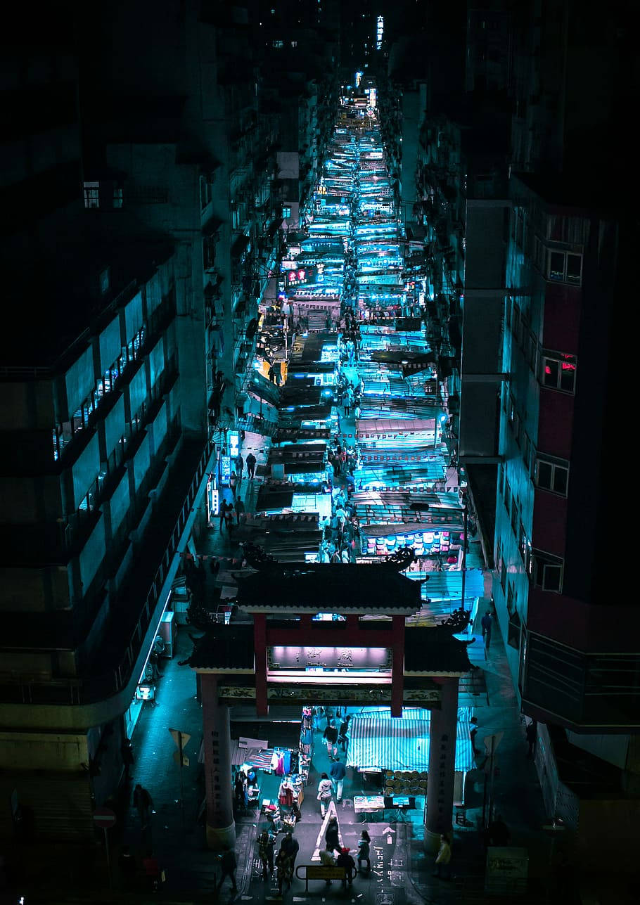 唐人街夜市 壁紙 — 密集市區中一條繁華的霓虹燈夜市街道的鳥瞰圖，有發光的攤位和行人。