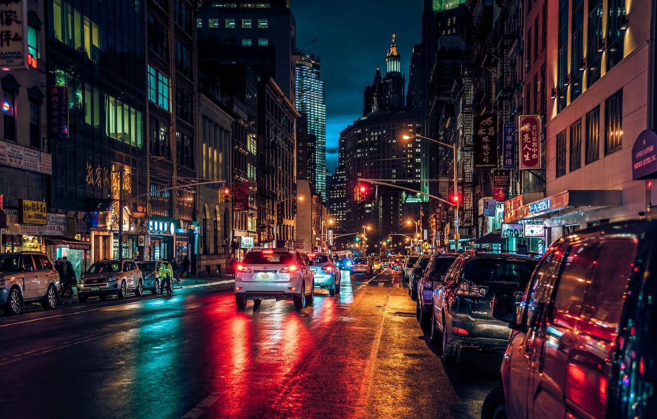 唐人街繁忙街道 壁紙 — 雨濕的夜晚城市街道，在黑暗的天空下反射來自汽車和建築物的霓虹燈光。