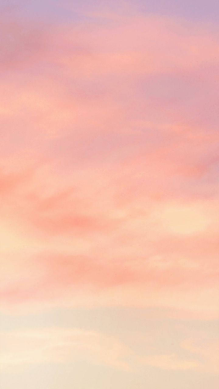 黎明或黃昏時分寧靜天空中柔和的粉紅色和薰衣草色雲彩。