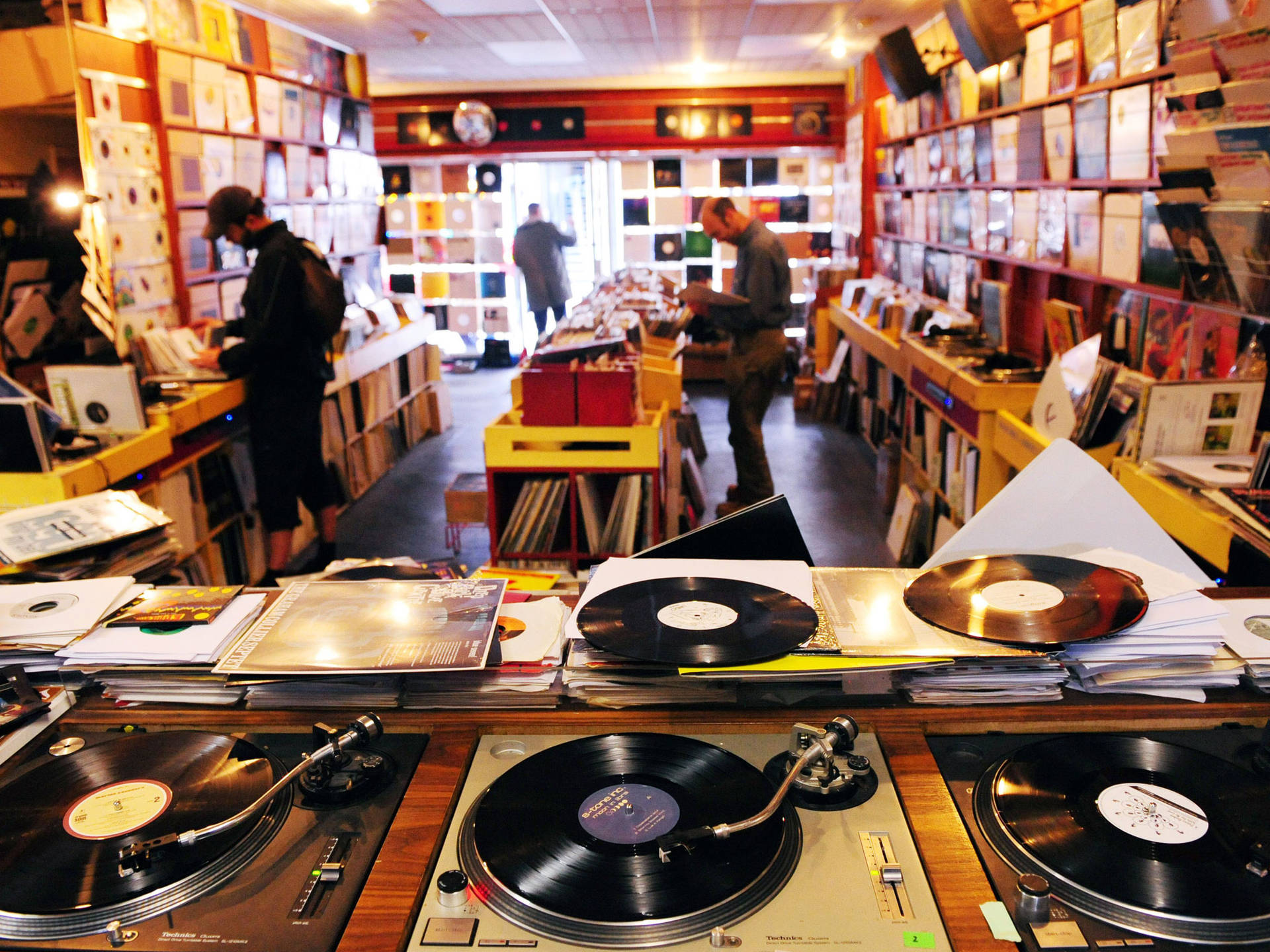 舒適的唱片店內，黑膠唱片和唱盤，顧客正在瀏覽。