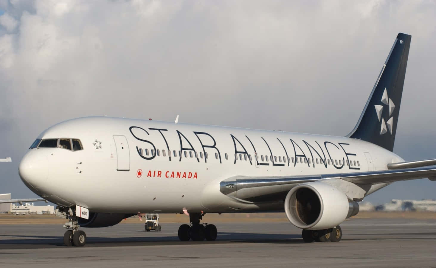 加拿大航空星空聯盟飛機在陰雲密布的天空下的機場停機坪上