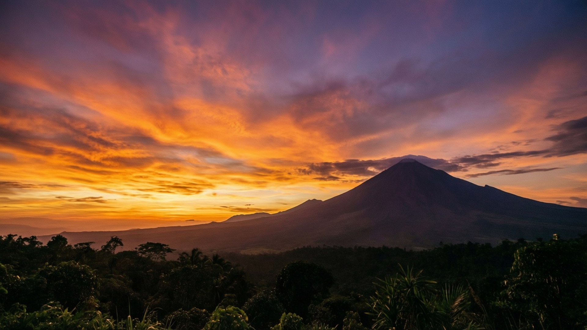 日落時分的火山，叢林上空有鮮豔的橙色和紫色天空