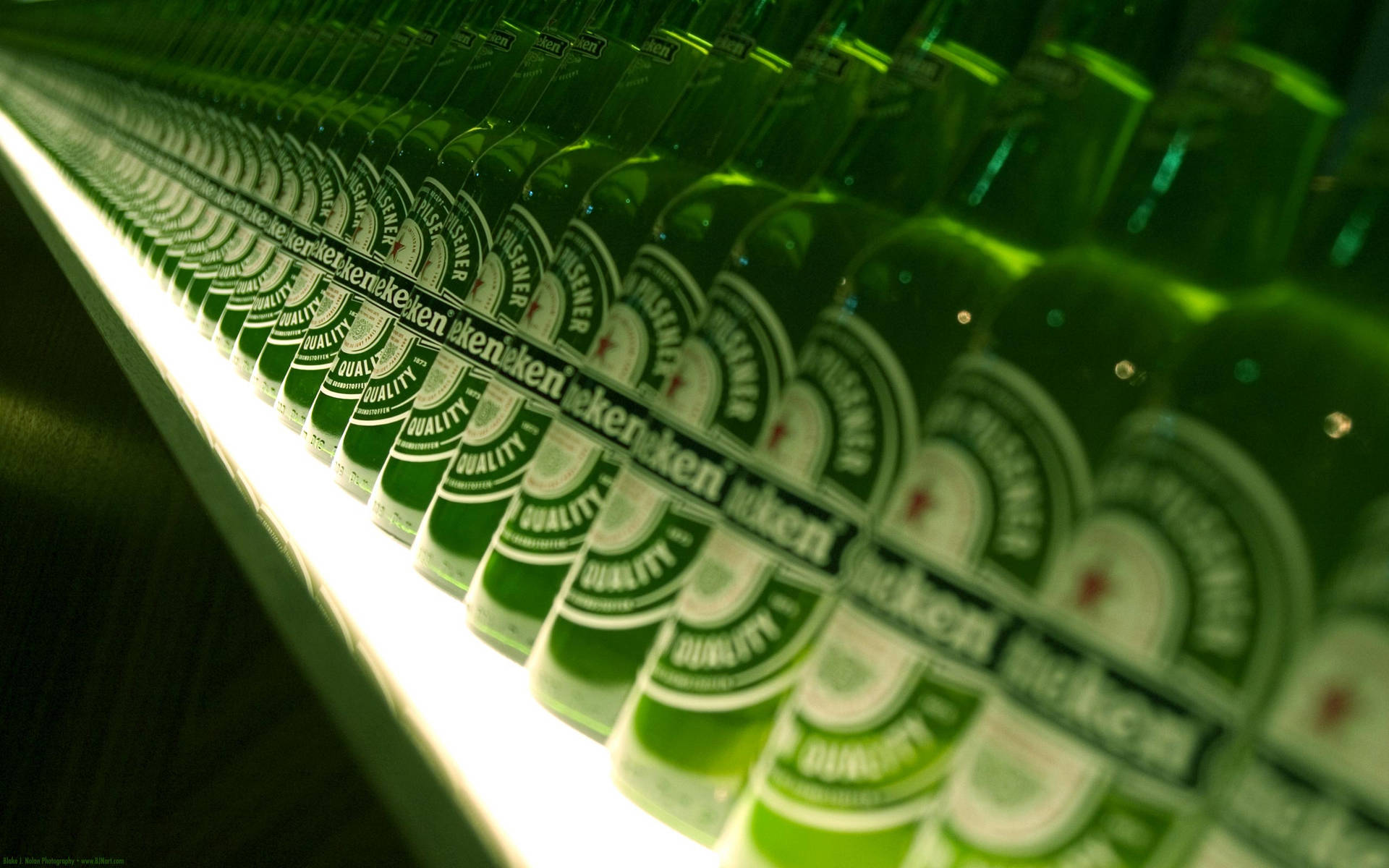 冷藏展示櫃中的一排排綠色喜力啤酒瓶。