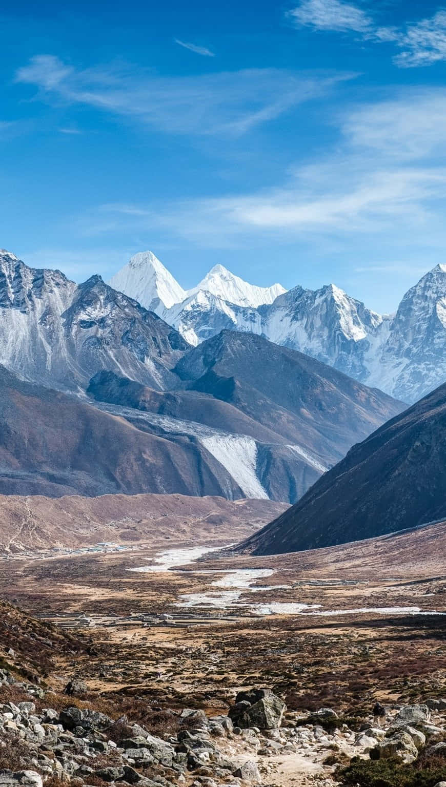 白雪覆蓋的山脈俯瞰著岩石山谷和蜿蜒的河流。