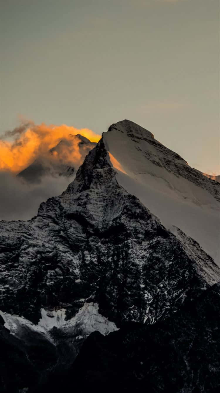 積雪的山峰在霧雲之上閃耀著日出光芒。