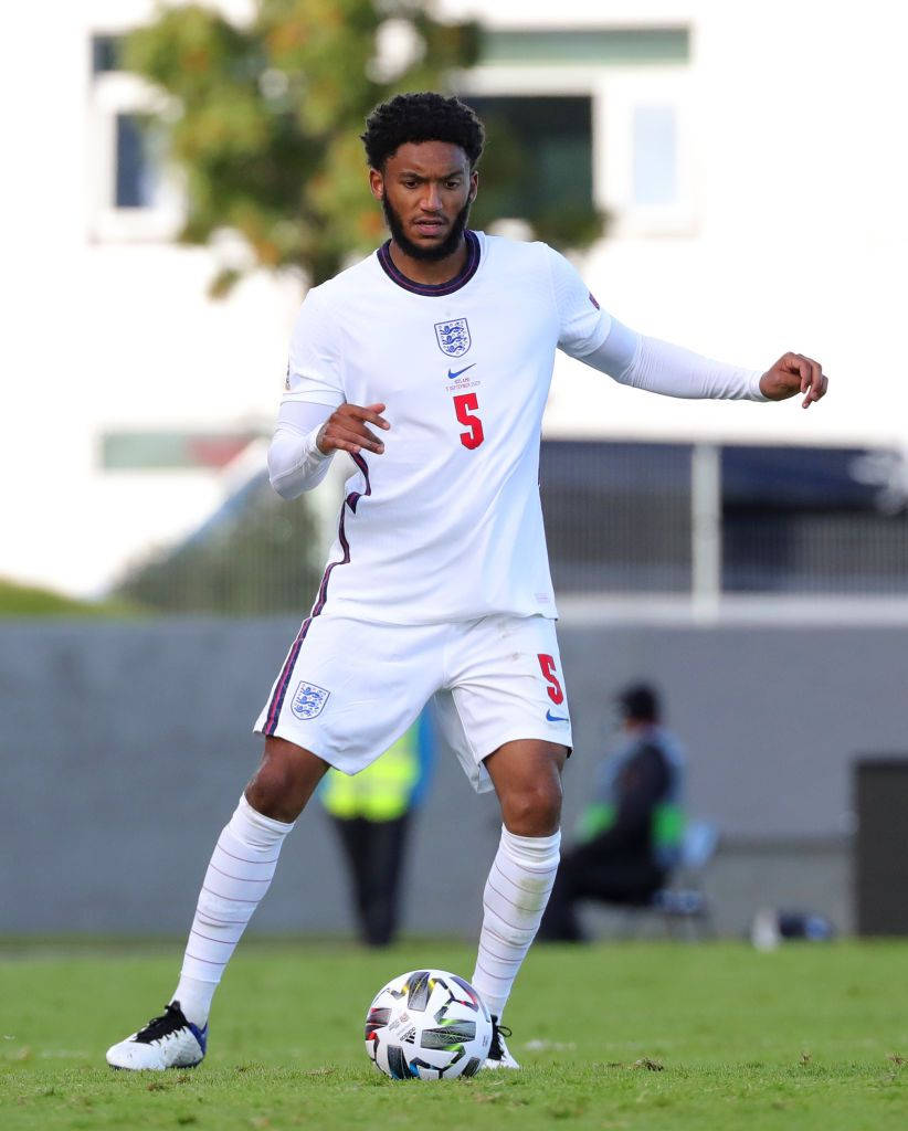 英格蘭足球員在草地上運球。
