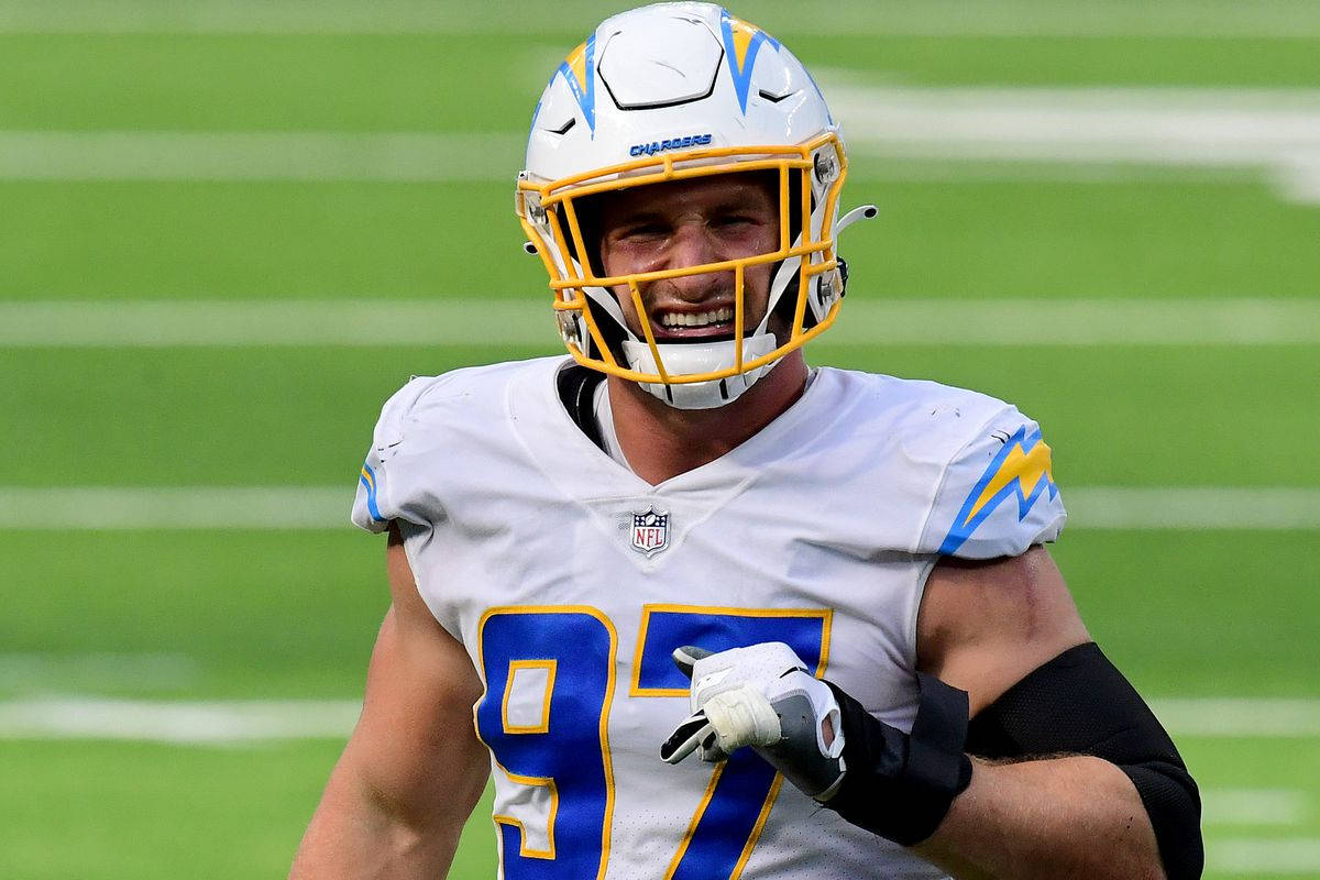 NFL足球運動員穿著Chargers制服在草地上奔跑。