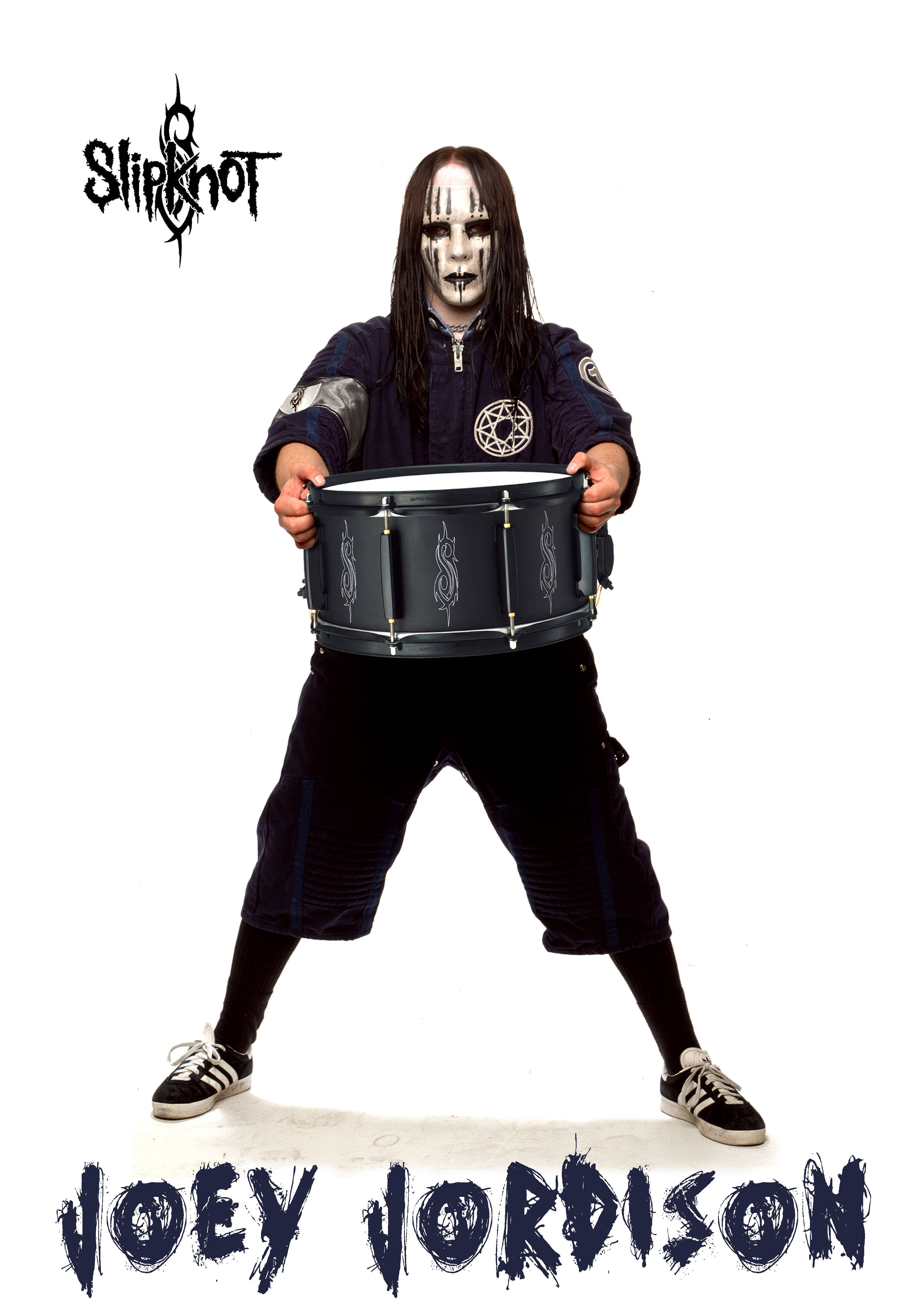 喬伊·喬迪森鼓 壁紙 — Slipknot 的 Joey Jordison 以寬闊的姿勢站立，手持黑色鼓，臉上塗有白色顏料，長長的深色頭髮，背景是純白色。