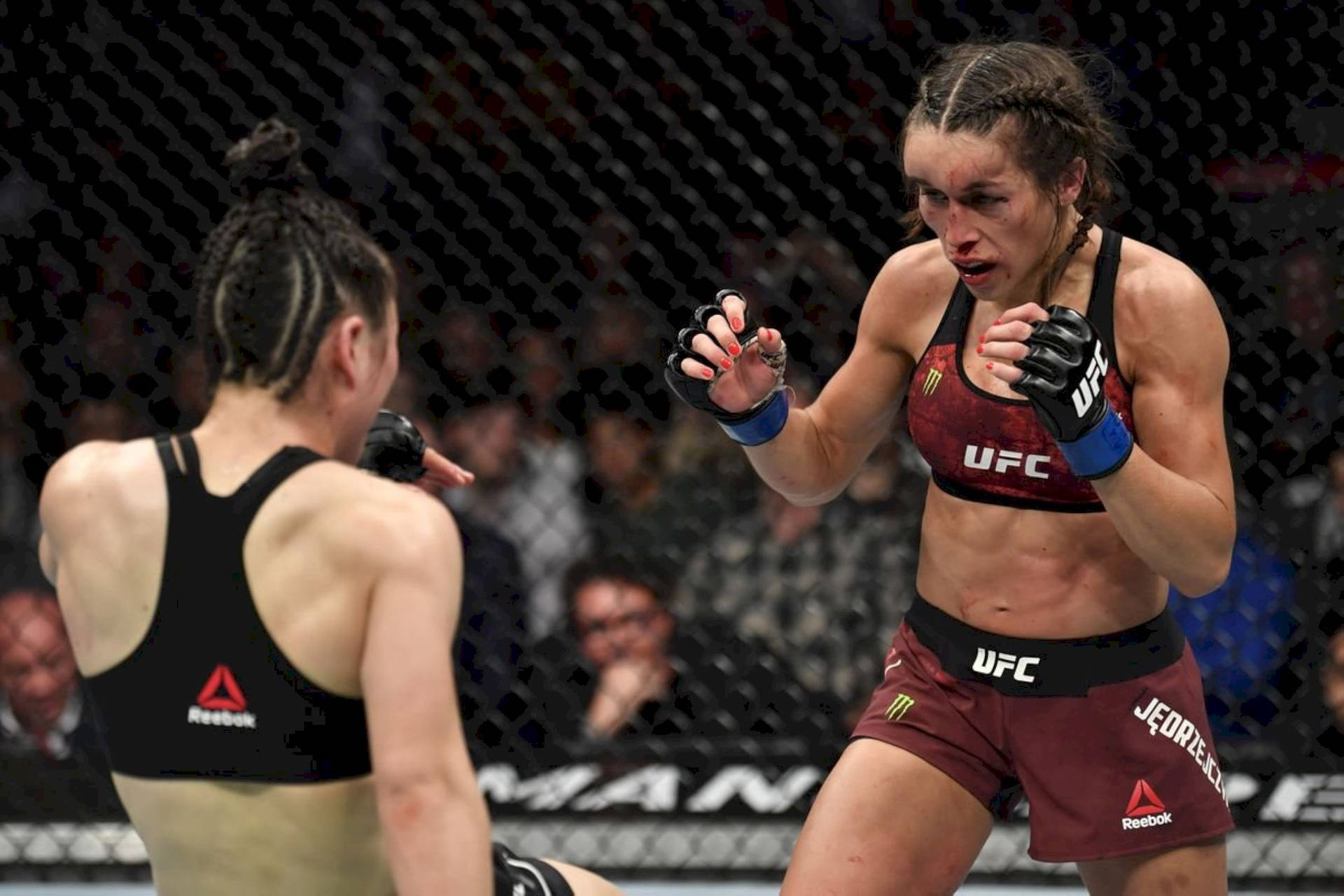 UFC比賽中，兩名女性拳手在籠內，一人前衝。