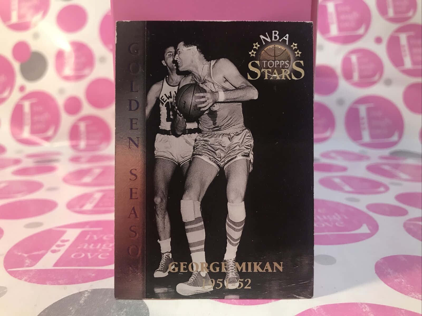 粉紅圓點背景上的George Mikan復古籃球交易卡。