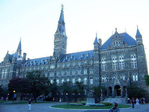 哥德式大學建築，擁有石塔和人們在暮色中在校園漫步。
