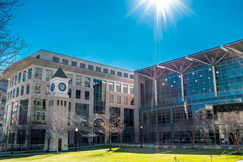 現代大學建築與鐘樓，在明亮陽光和光禿樹木下