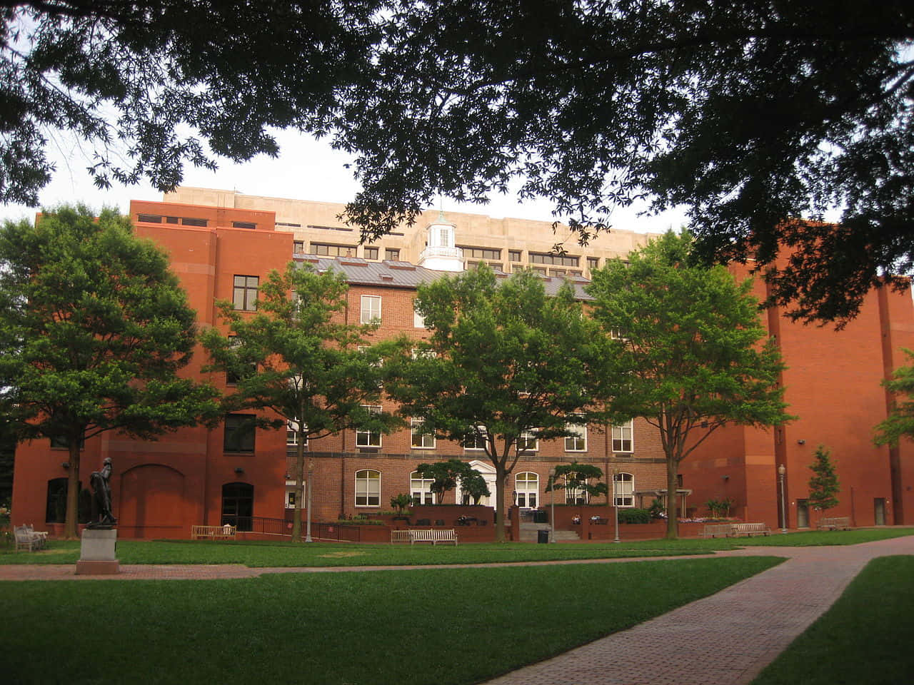 大學校園，擁有磚造建築和綠樹，在日光下。