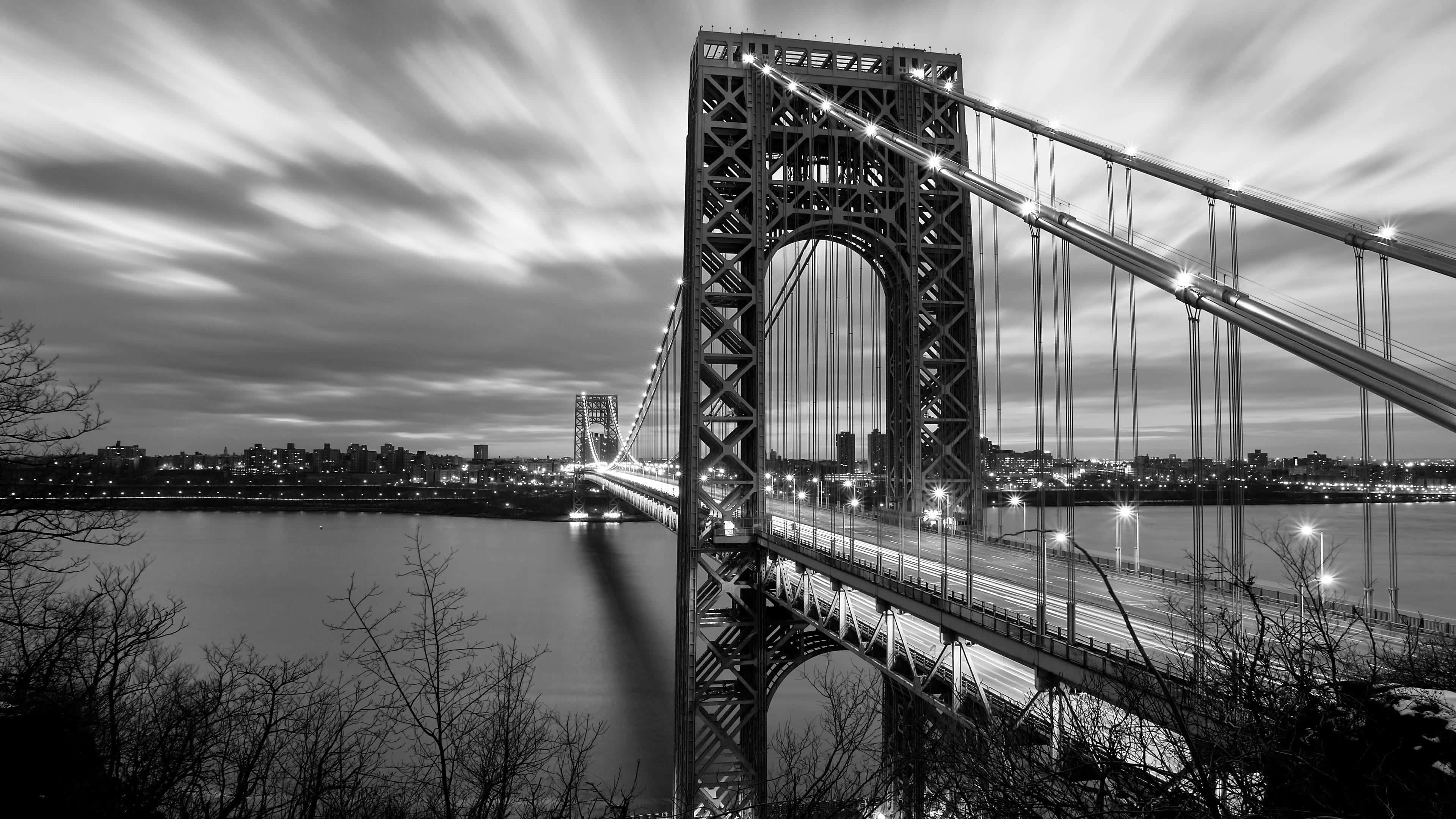 Black And White Cityscape 桌布 壁紙 — 喬治華盛頓大橋在黃昏時分的黑白長時間曝光照片，帶有車流燈光和城市燈光。
