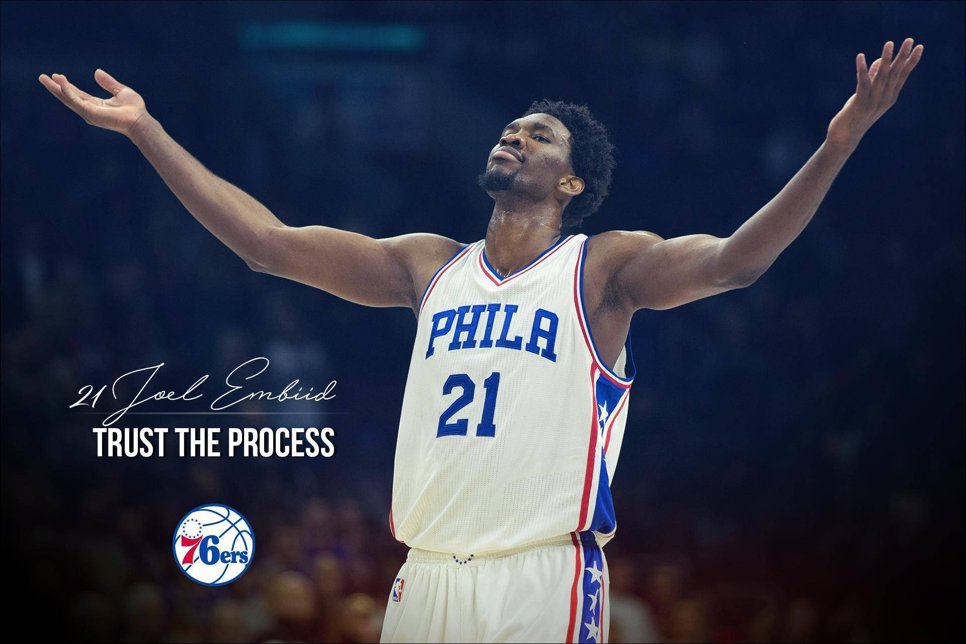 Joel Embiid 身穿白色球衣，高舉雙臂慶祝，帶有「Trust The Process」文字。