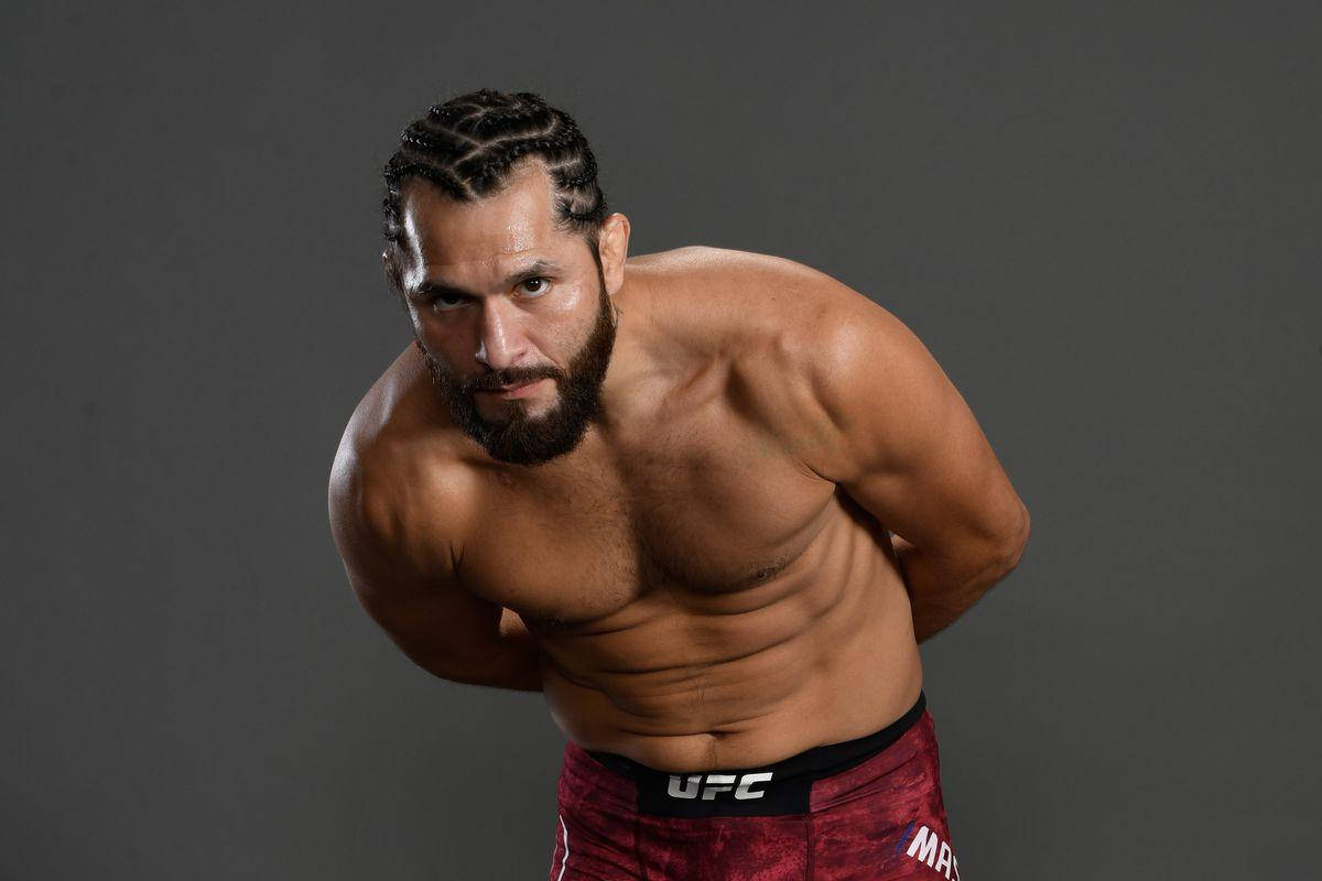 肌肉發達的UFC戰士留鬍子，穿著紅色短褲在工作室中激烈擺姿勢。