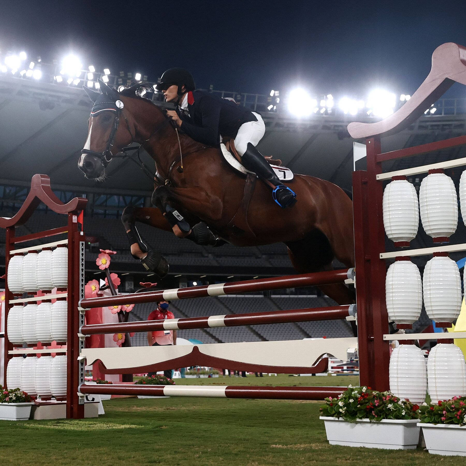 馬術運動員和馬在夜間體育場燈光下越過障礙物。 — 賽馬 壁紙