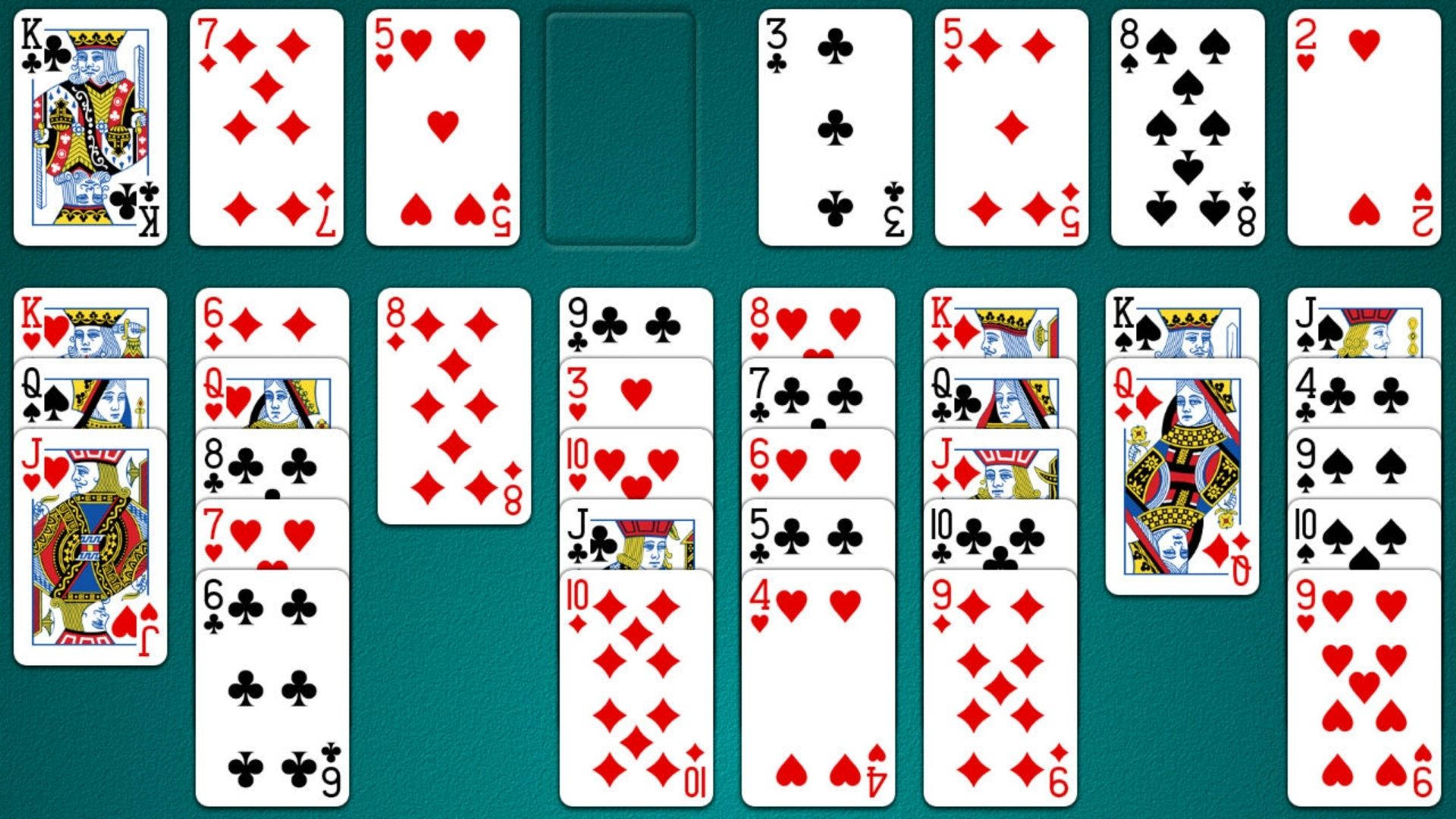 單人紙牌遊戲顯示 壁紙 — 經典接龍紙牌遊戲，擺放在綠色氈面上，紙牌呈扇形展開並堆疊成列。
