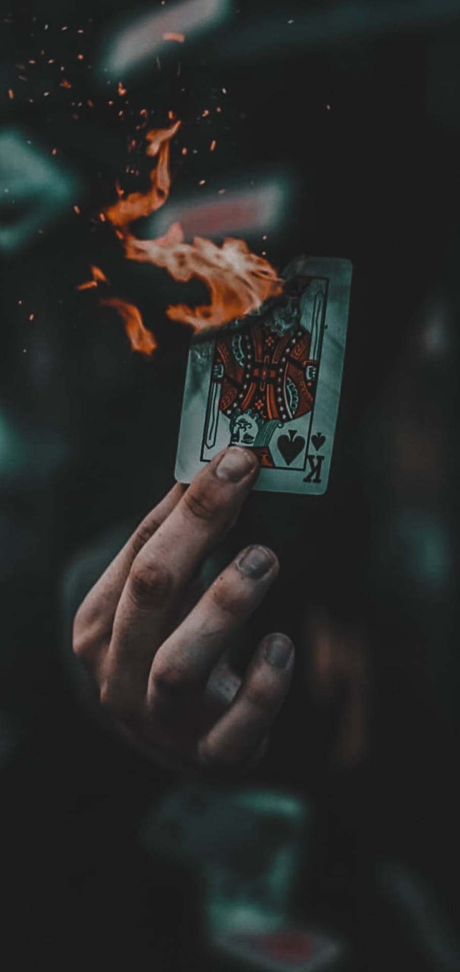 手拿著燃燒的紅心K牌，火花四濺