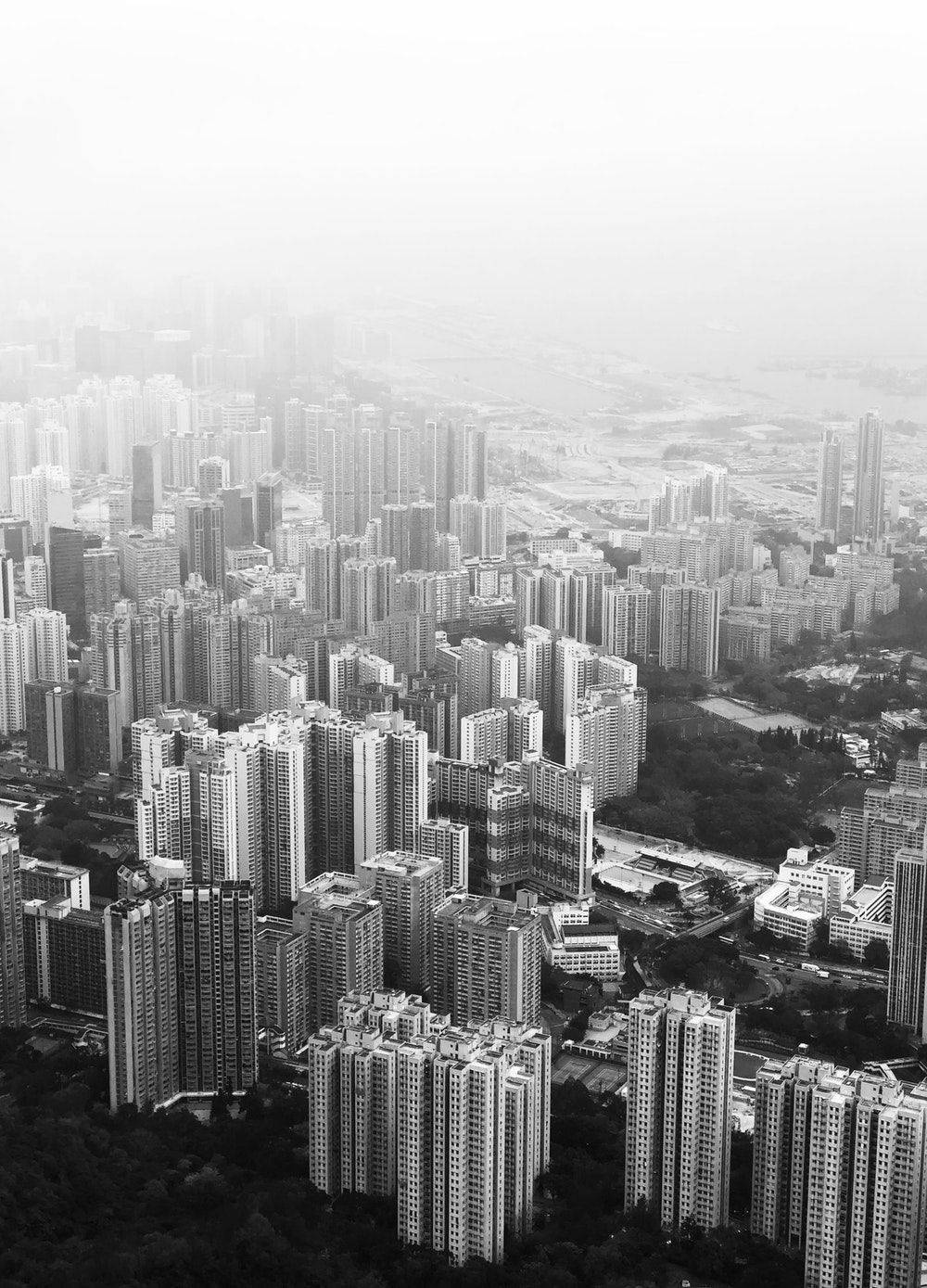 單色城市 壁紙 — 一張單色航拍圖，展示密集的城市天際線，高聳的摩天大樓逐漸融入大氣霧霾中。