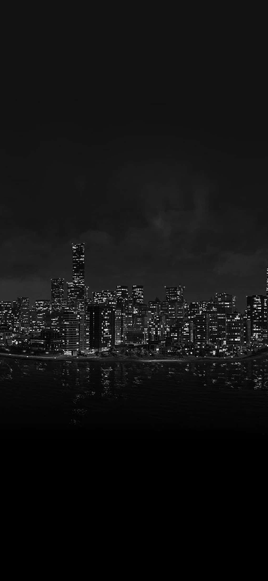 鎖屏 桌布 壁紙 — 單色城市天際線夜景，發光的窗戶倒映在陰天下的暗水中。