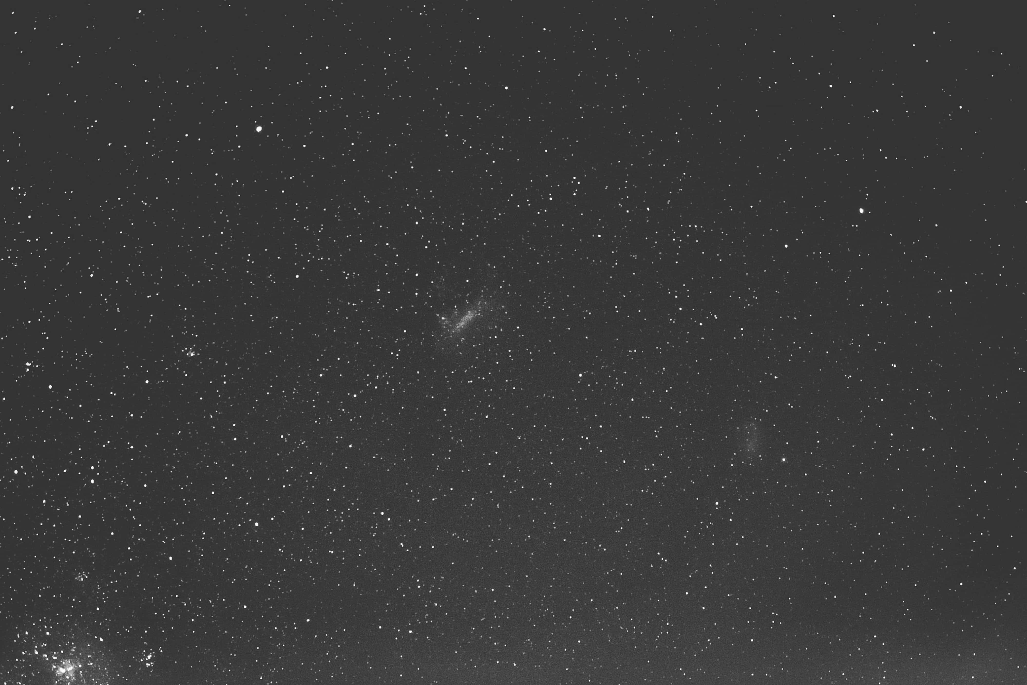 Black Space 桌布 壁紙 — 單色夜空，充滿無數星星和微弱發光的星雲，背景漆黑。