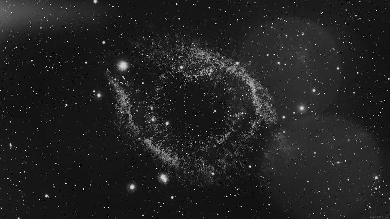 Dark Galaxy 桌布 壁紙 — 單色宇宙星雲在星空背景下旋轉，帶有發光粒子。