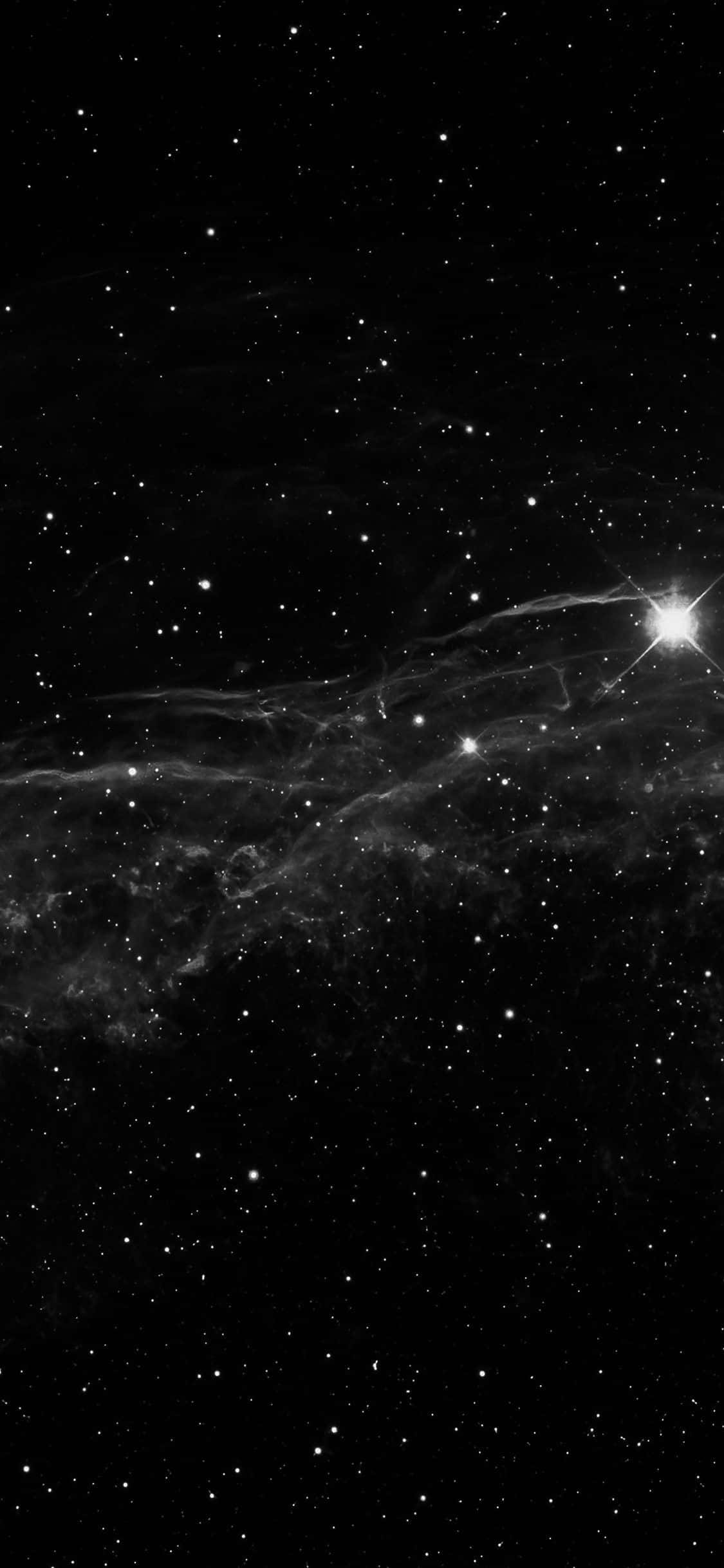 Dark Sky 桌布 壁紙 — 單色宇宙景觀，展示一顆明亮的恆星照亮了縹緲的星雲，背景是無數遙遠的恆星。
