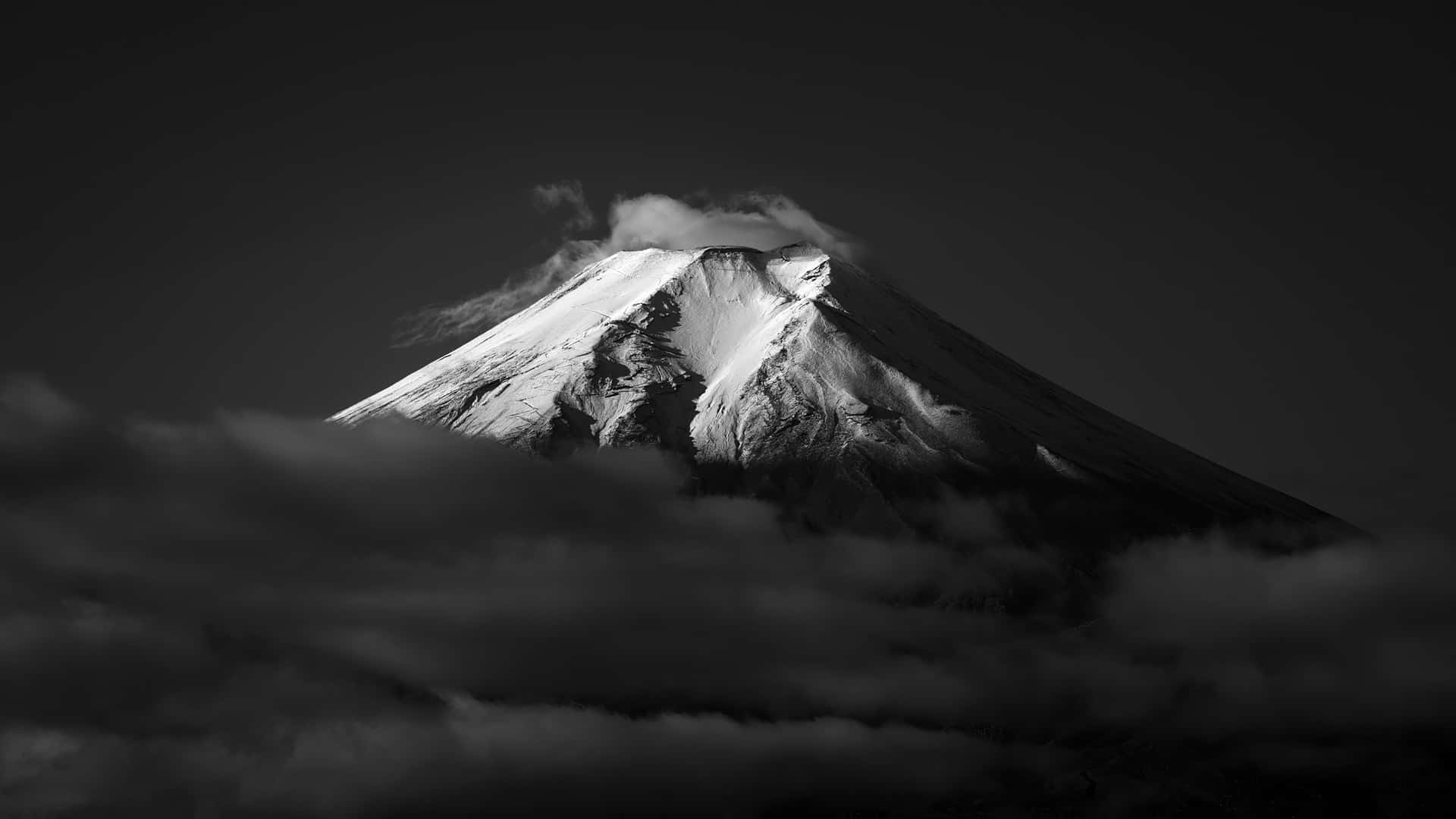 白雪覆蓋的山峰從黑白相間的烏雲中浮現。