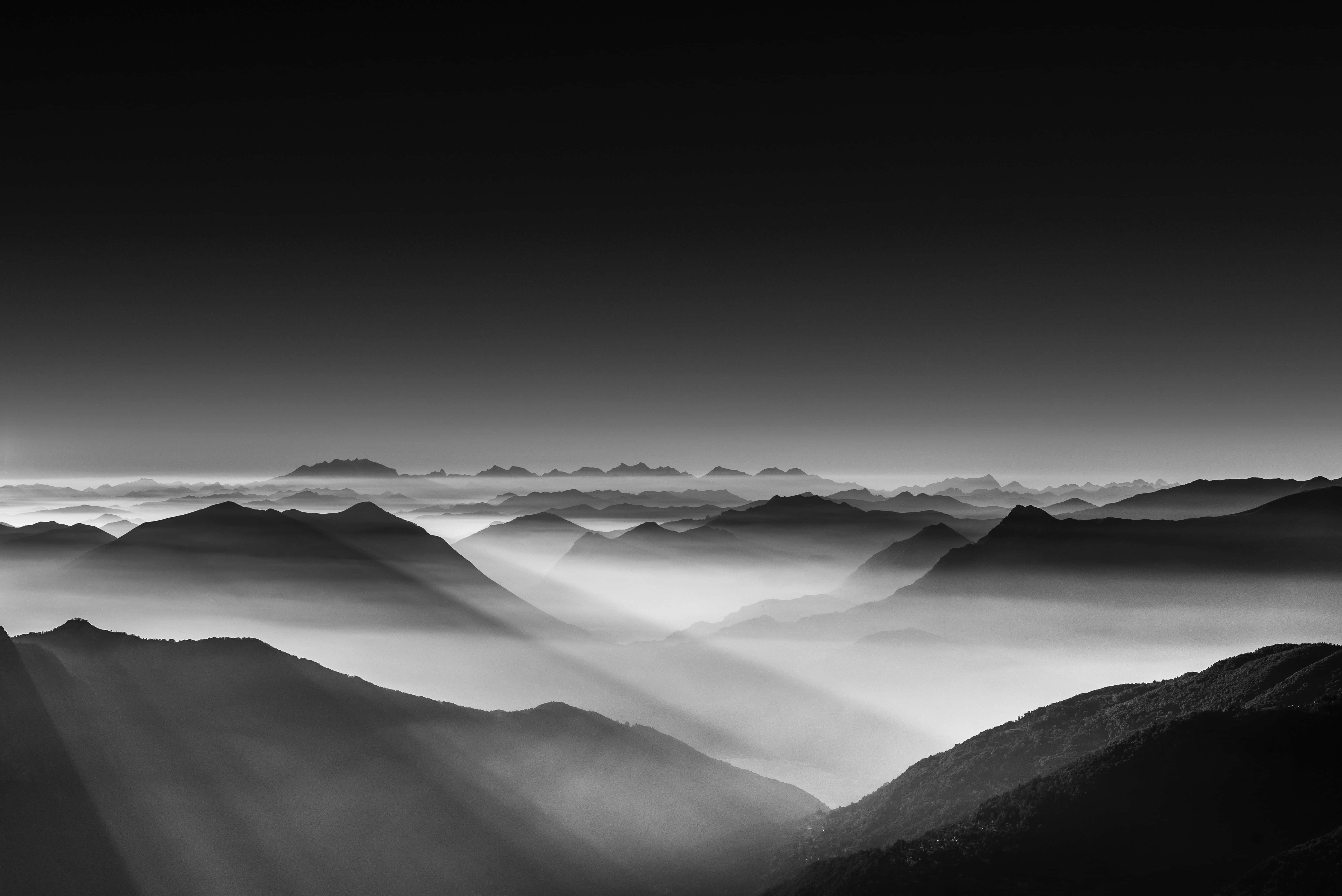 Black And White Landscape 桌布 壁紙 — 單色山脊穿透層層薄霧，戲劇性的光線劃破霧靄。