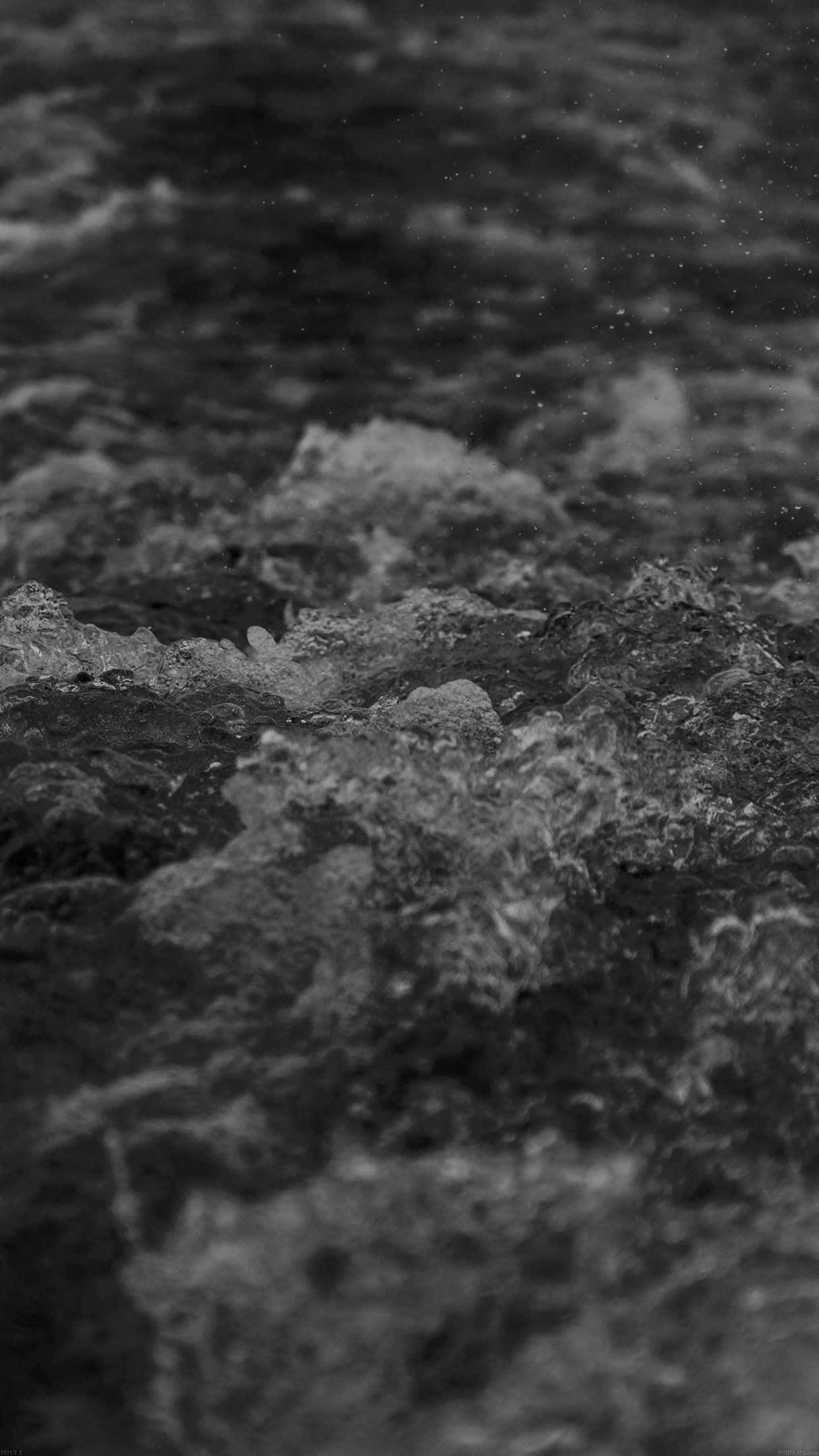 Dark Ocean 桌布 壁紙 — 單色特寫，湍急水流在暗色岩石上翻湧，帶有白色泡沫浪花和霧狀水滴。