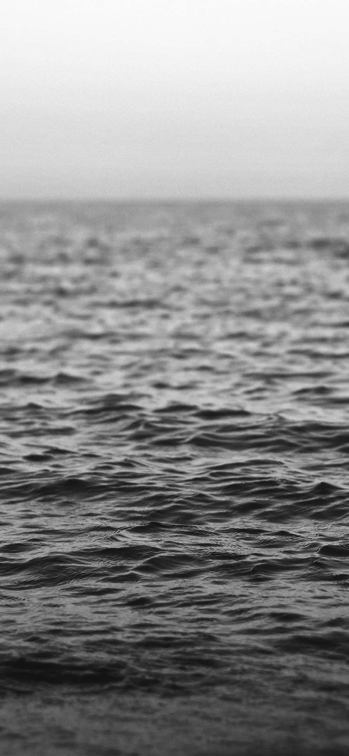 Black And White Ocean 桌布 壁紙 — 單色特寫，紋理化的海浪在陰天與朦朧的地平線相遇。