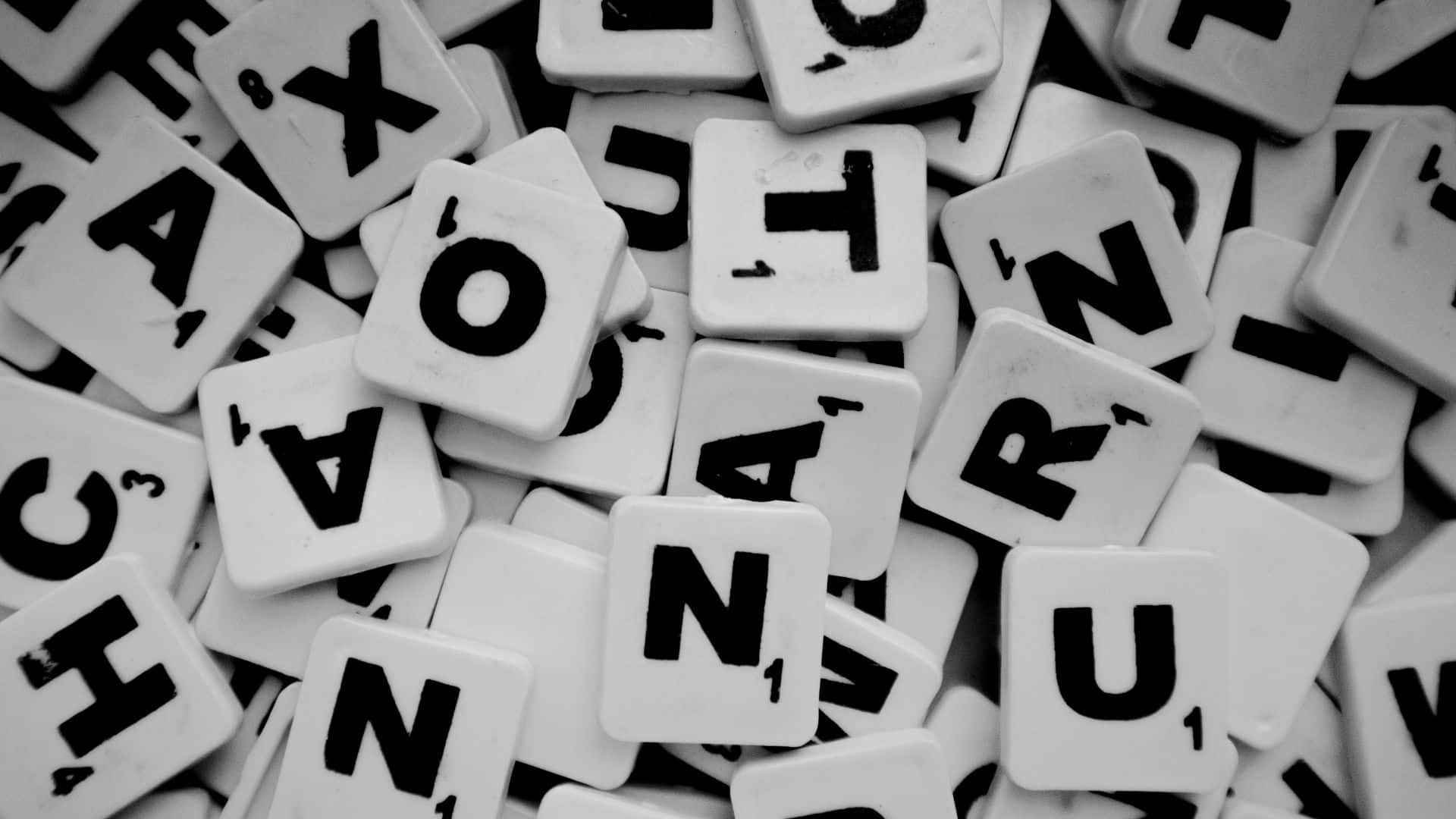 Typography 桌布 壁紙 — 單色特寫散落的 Scrabble 字母牌拼出單詞和字母。