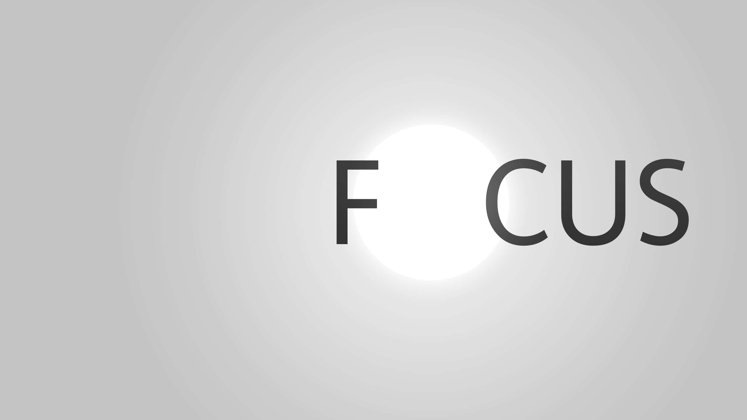 Focus 桌布 壁紙 — 單詞 focus 中的字母 O 被一個明亮的白色圓圈取代，背景為柔和的灰色漸變。