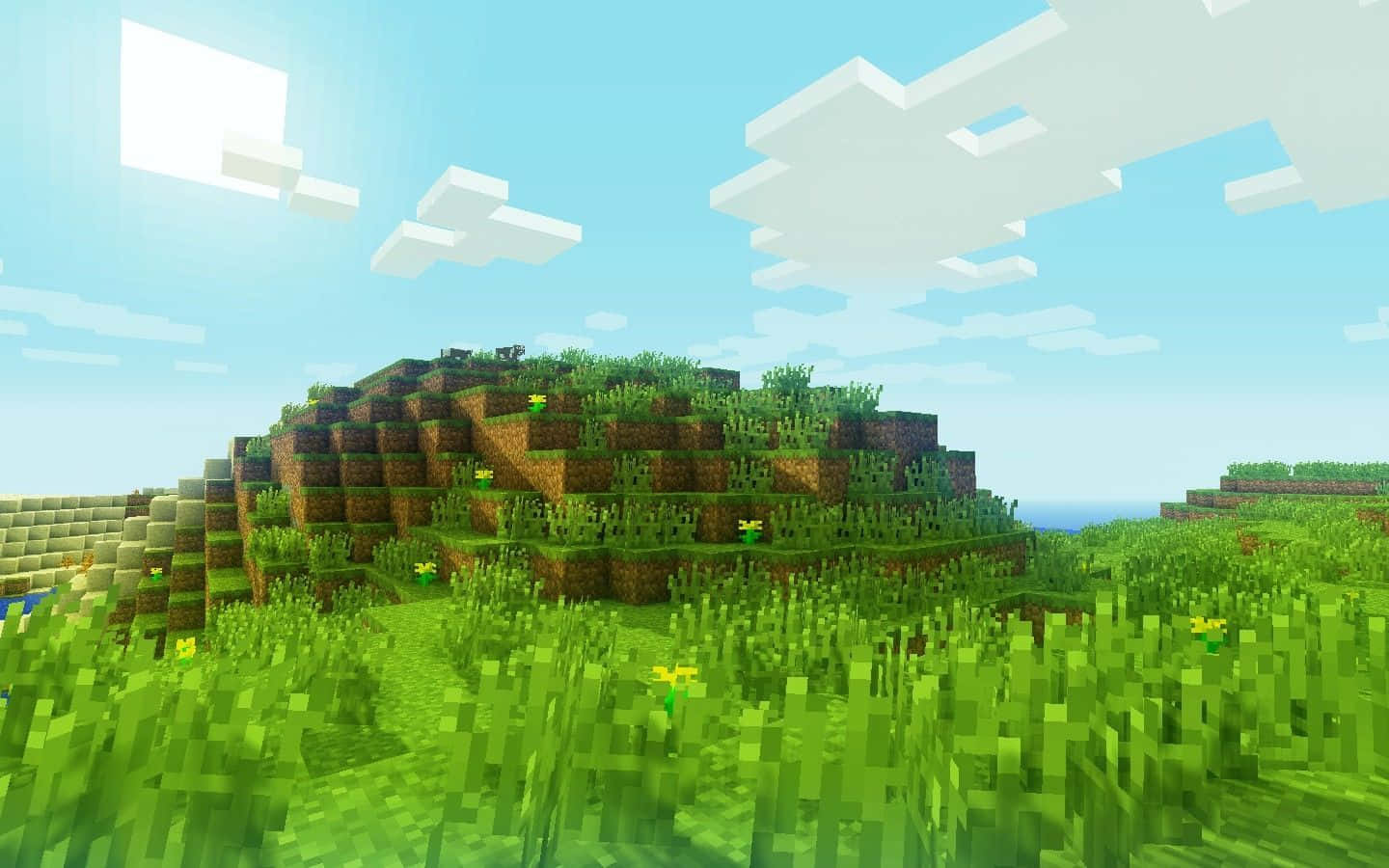 Minecraft Map 桌布 壁紙 — 喺Minecraft風景中，一個充滿活力嘅像素化草地山丘，喺明亮藍天下有方塊雲。