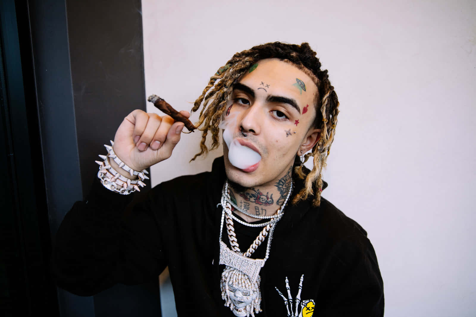 有紋身和辮子的男人拿著雪茄吹泡泡。
