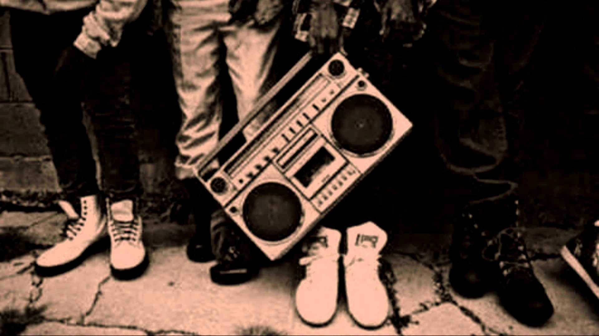 一群人在裂開的人行道上拿著手提音箱，附近有運動鞋。