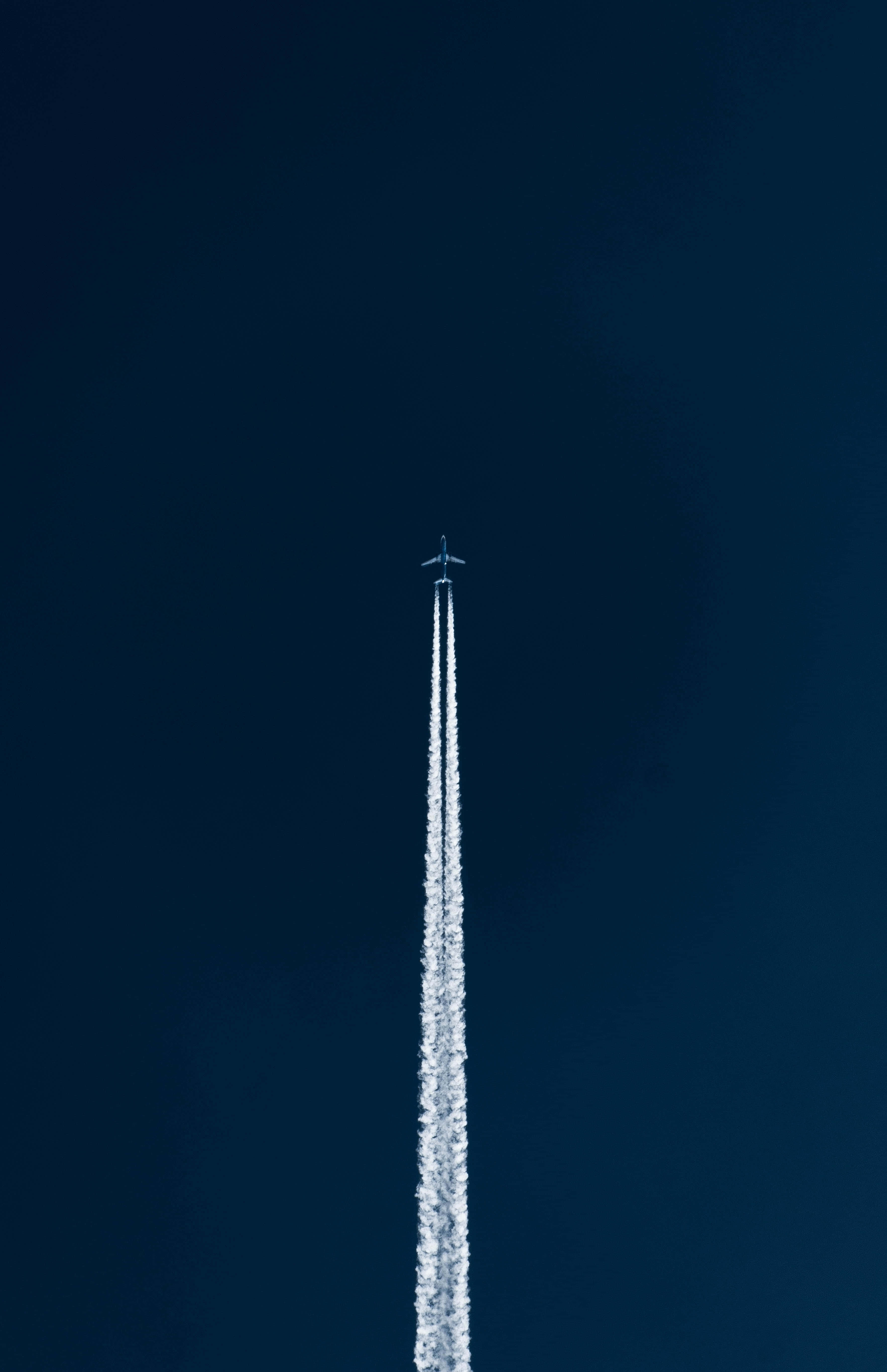 噴氣機飛行留煙 Android 飛機背景 壁紙 — 一架孤獨的飛機在深藍色的天空中垂直上升，留下一道長長的白煙。